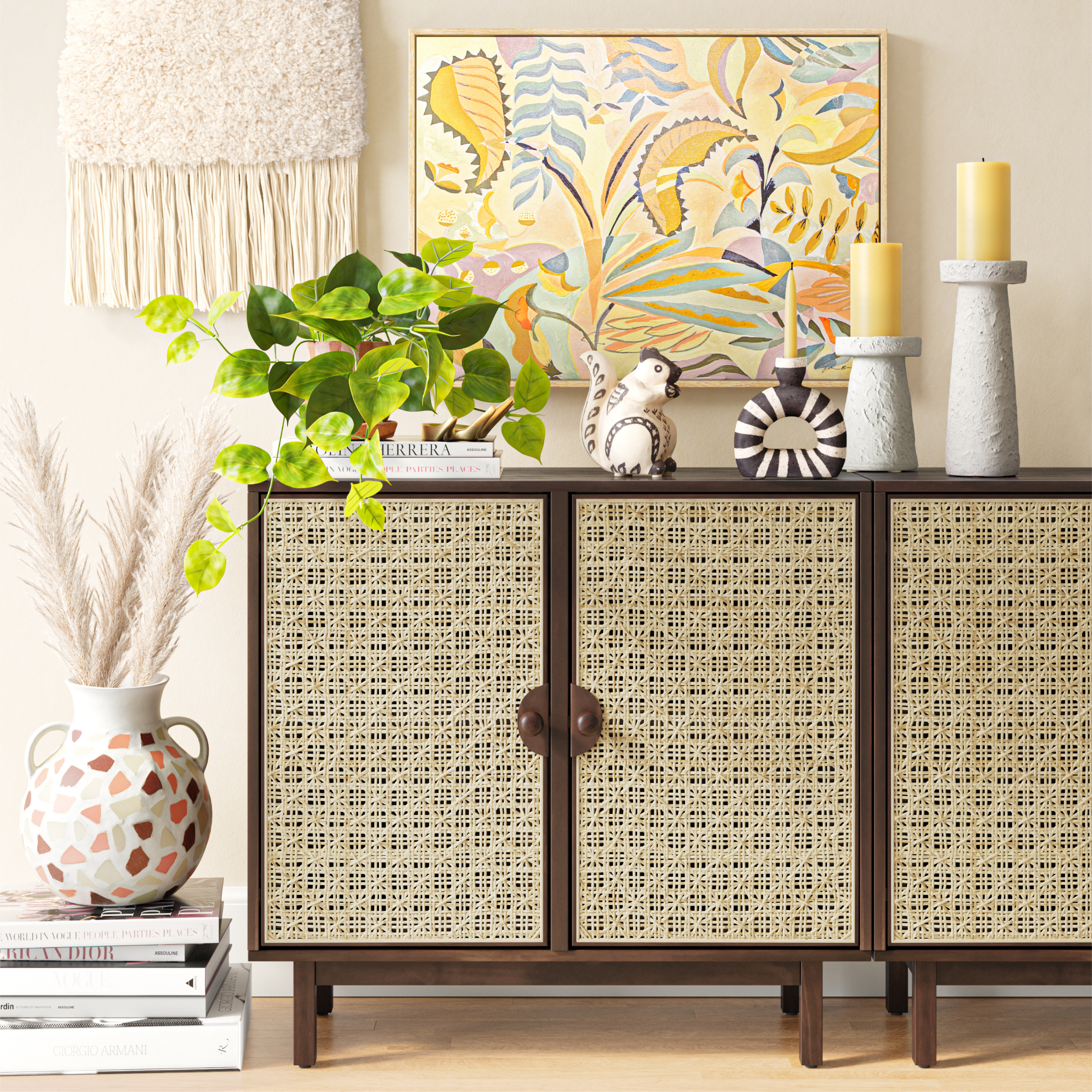 Living room sideboard decorated with potted plant, ceramics, candles, and a colorful abstract painting.