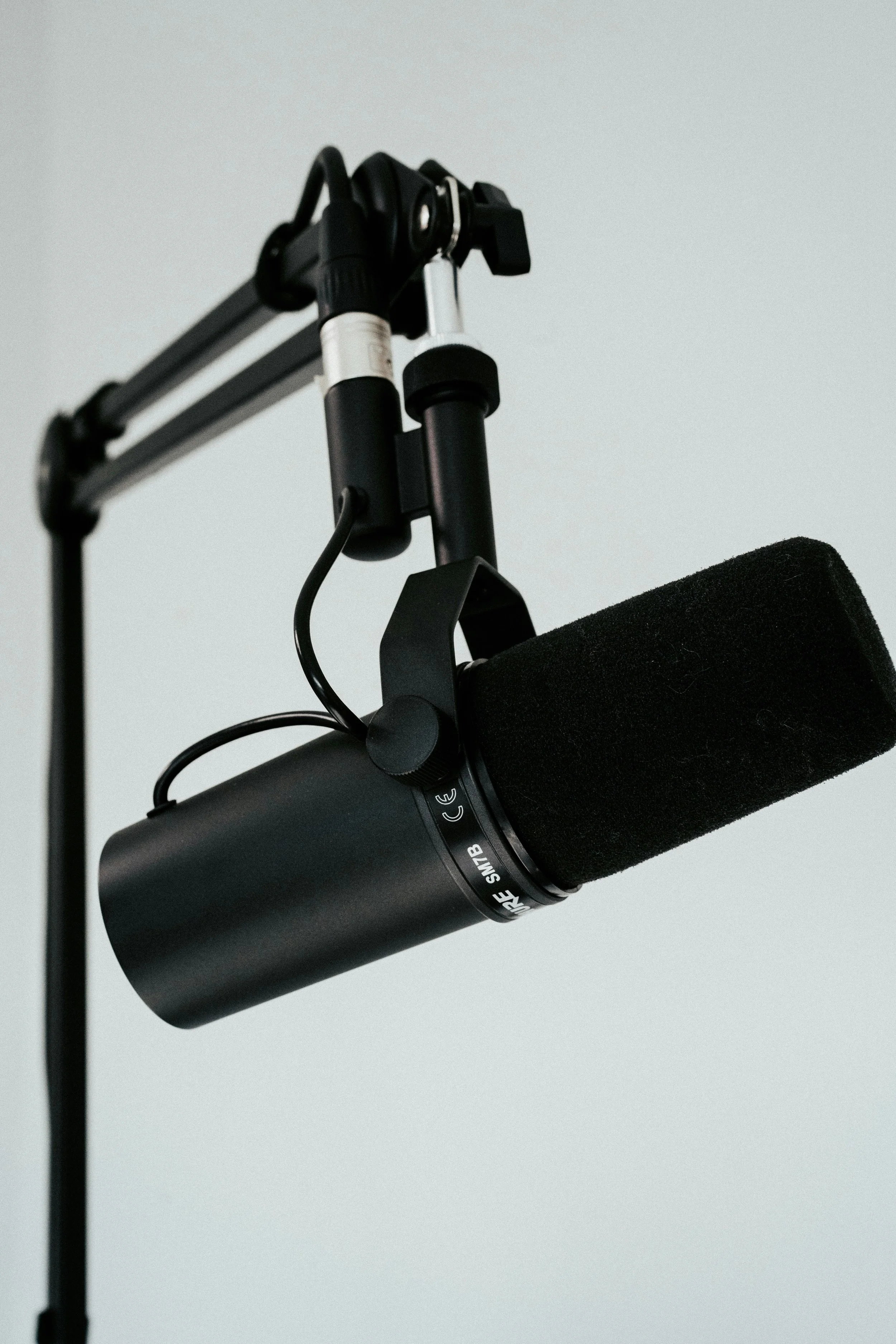 Close-up of a professional microphone mounted on a boom arm.