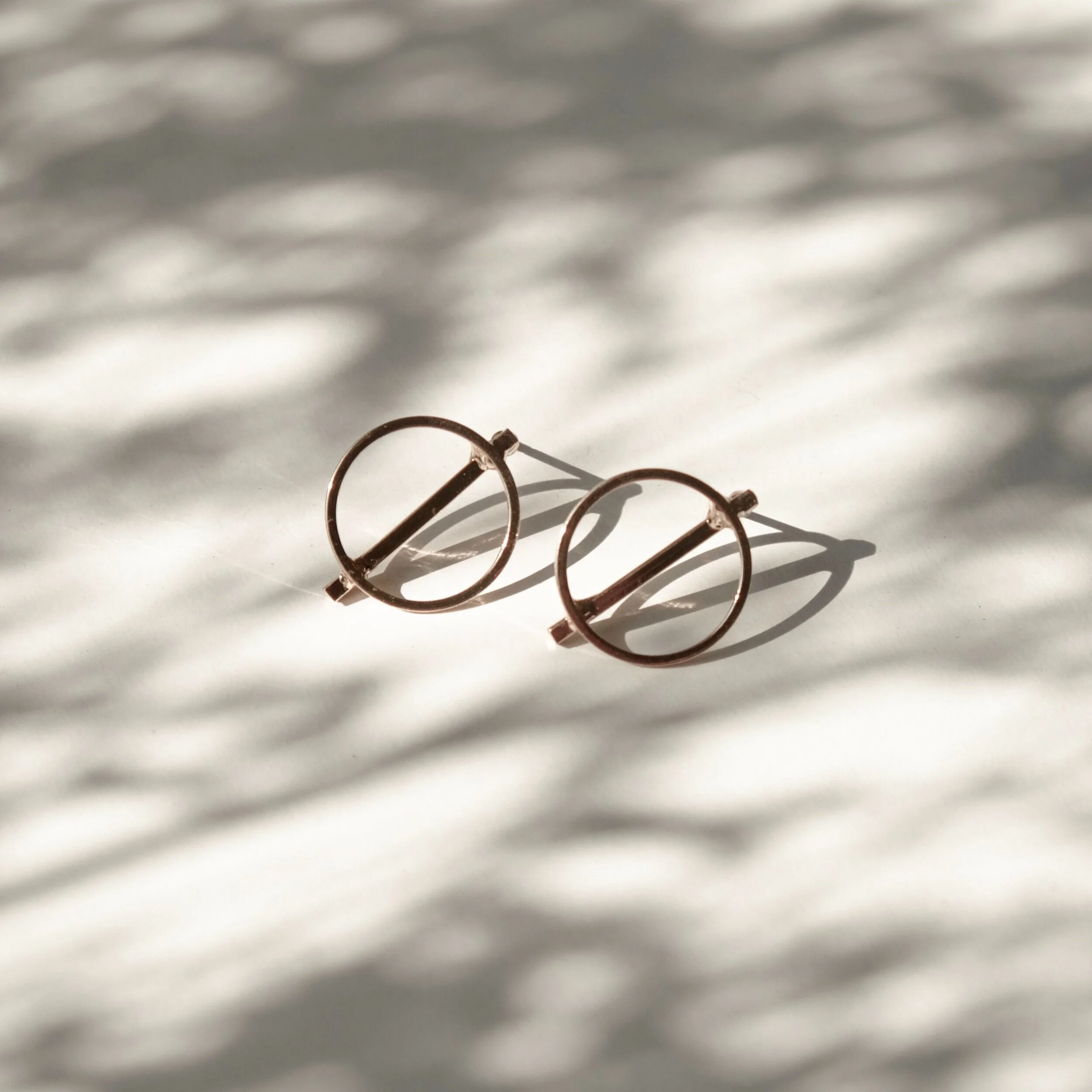 A close-up of metal sunglasses resting on a surface.