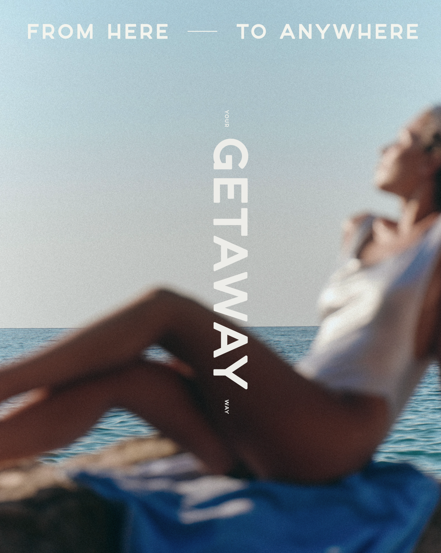 A person is relaxing by the ocean, with the view of the sea and a clear sky in the background. The individual appears to be enjoying the moment, possibly lying down or reclining.