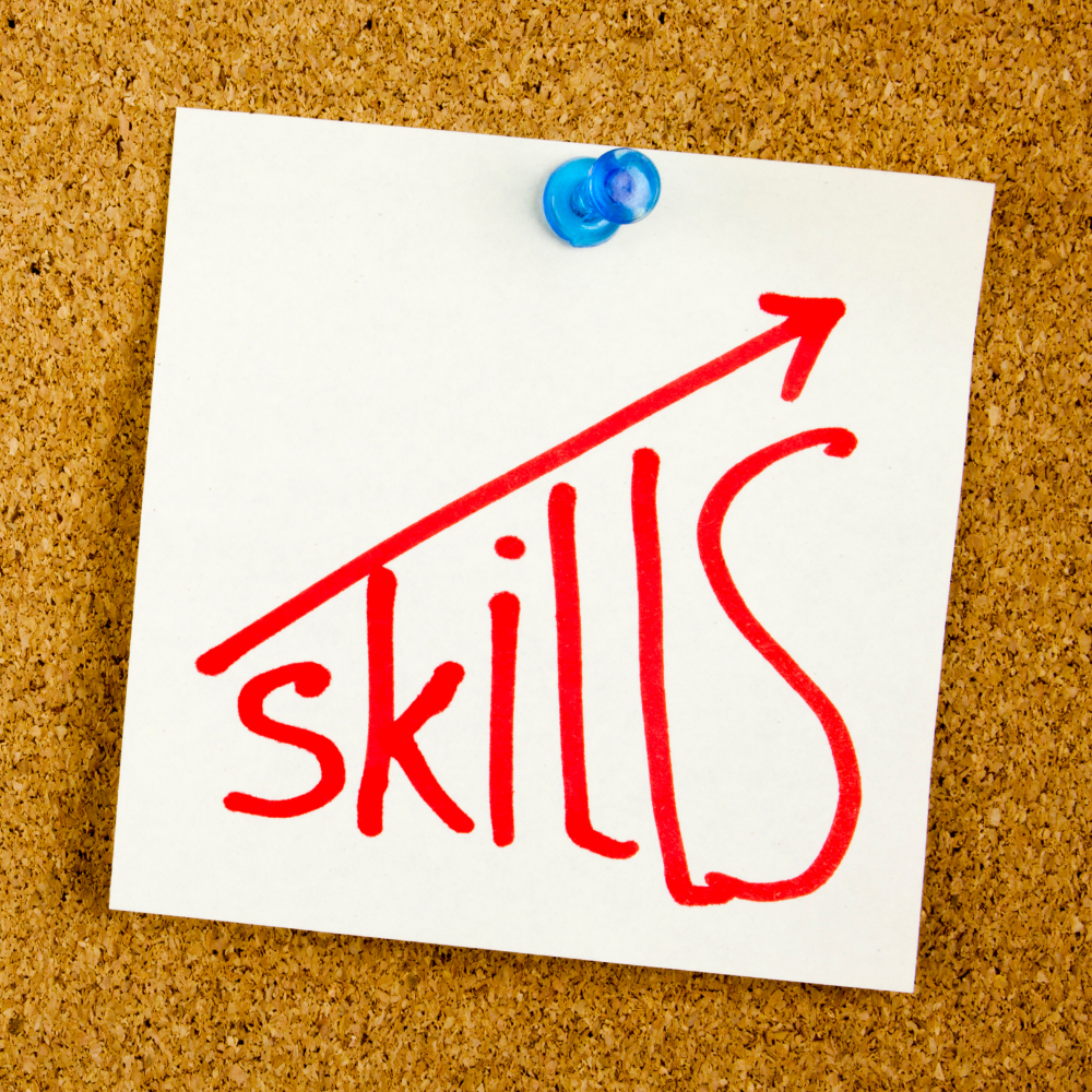 Notepad with the word 'skills' written in red, and an upward arrow extending from the word.