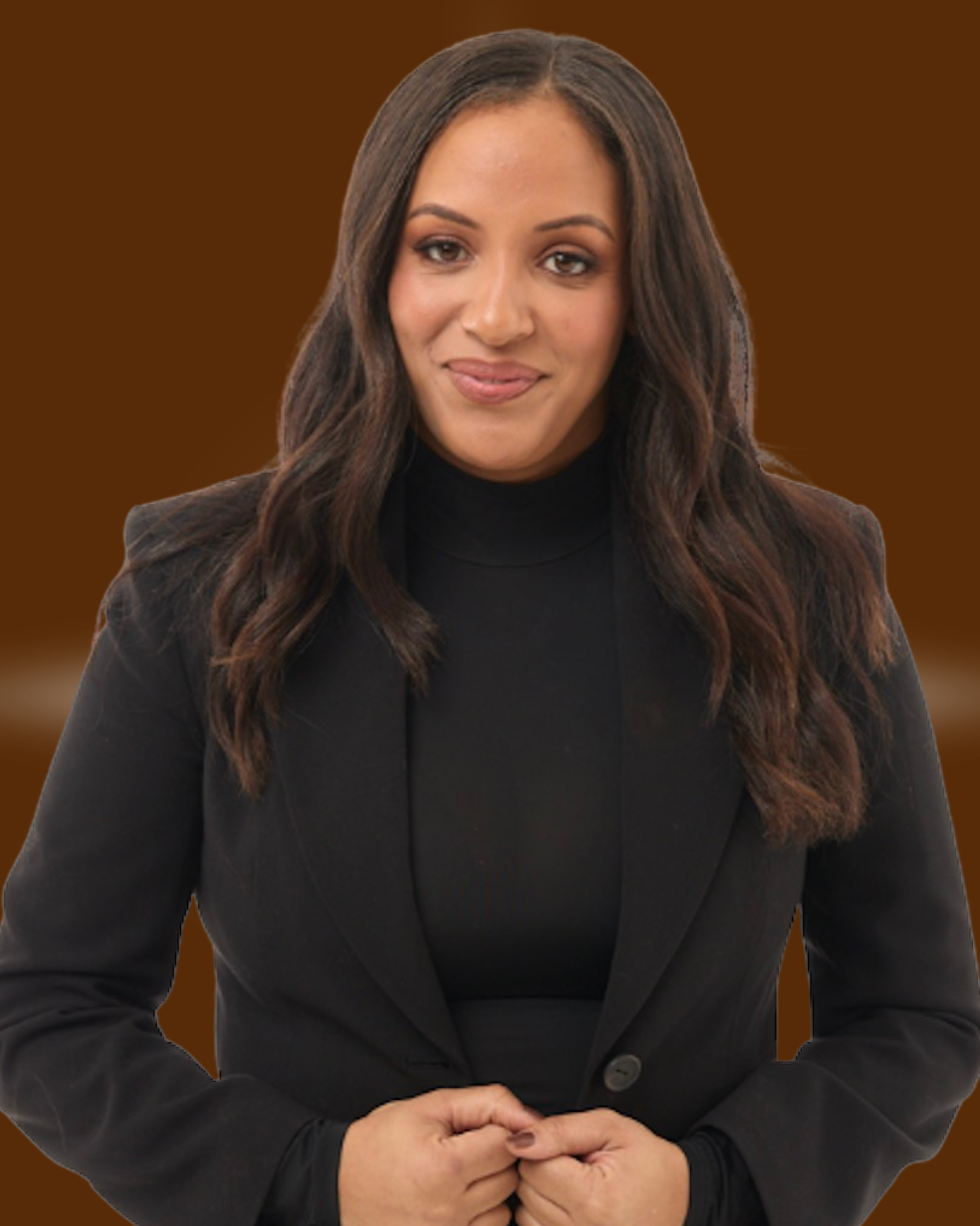 A woman with long wavy dark hair wearing a black blazer and black turtleneck, standing against a brown background.