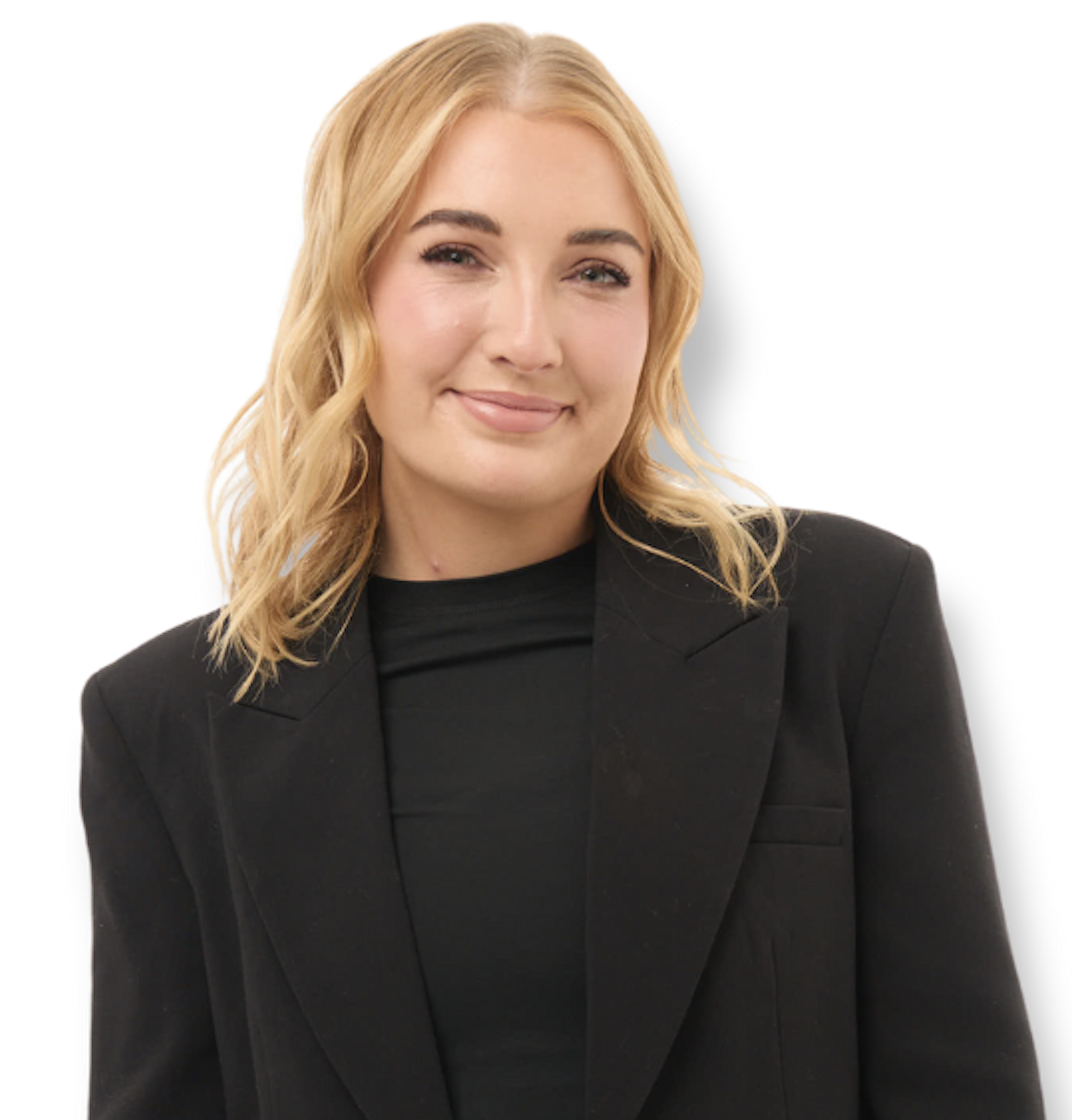 A woman with shoulder-length blonde hair wearing a black blazer and black top, smiling against a white background.