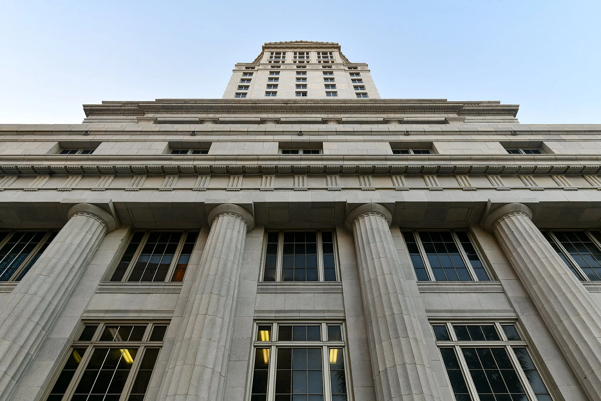 Looking up at a tall, historic building with classical architectural features including columns and detailed stonework.