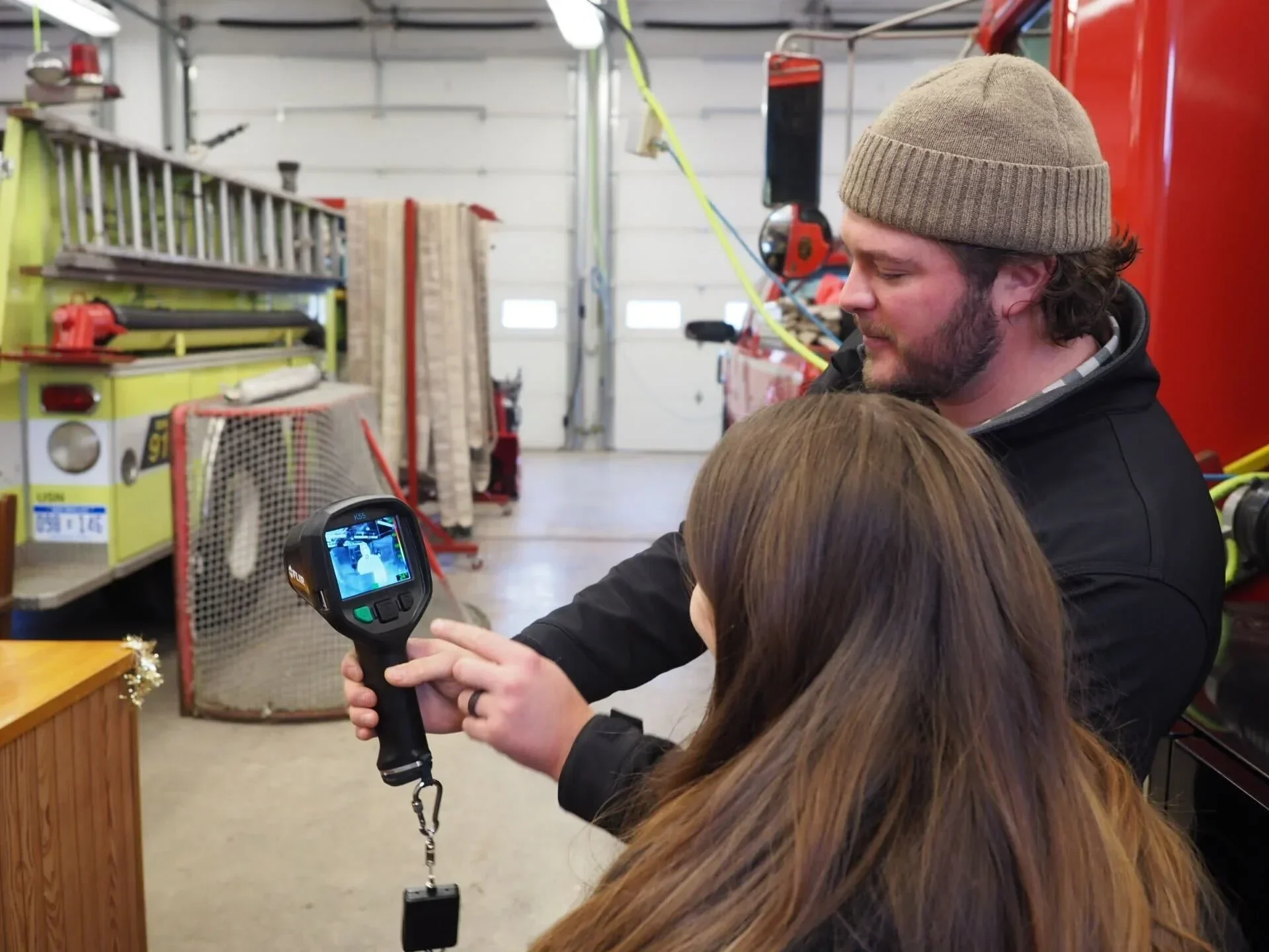  Volunteer firefighter, Hayden Henderson, shows how to operate the thermal camera and its features to Madelina DeLisi, KCF Director of Programs. 