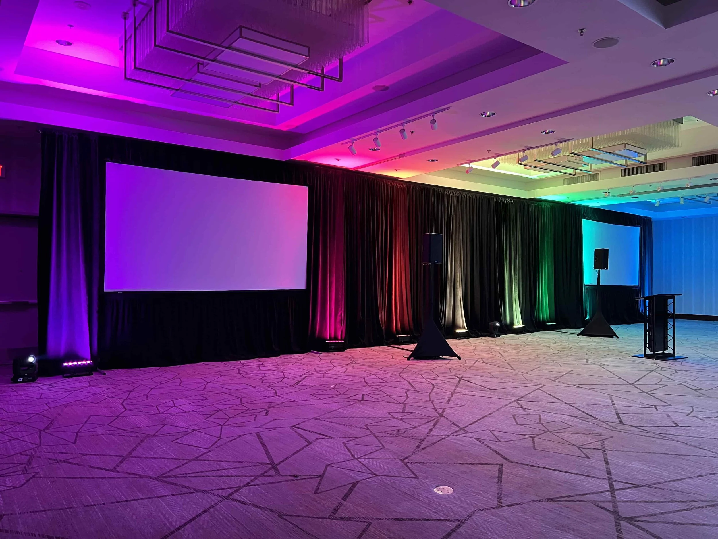 Multicolor stage lighting for a corporate event at a hotel ballroom.