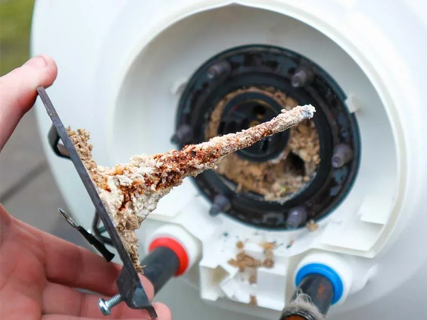 Person removing a lint filter or debris from a sink.