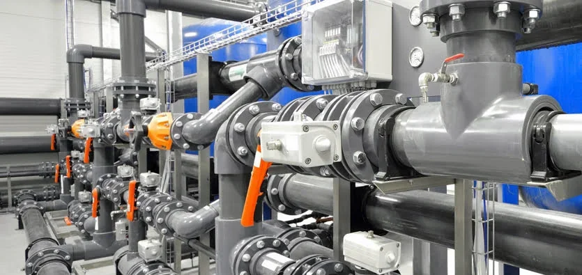 Industrial piping system with multiple valves, gauges, and fittings in a facility.