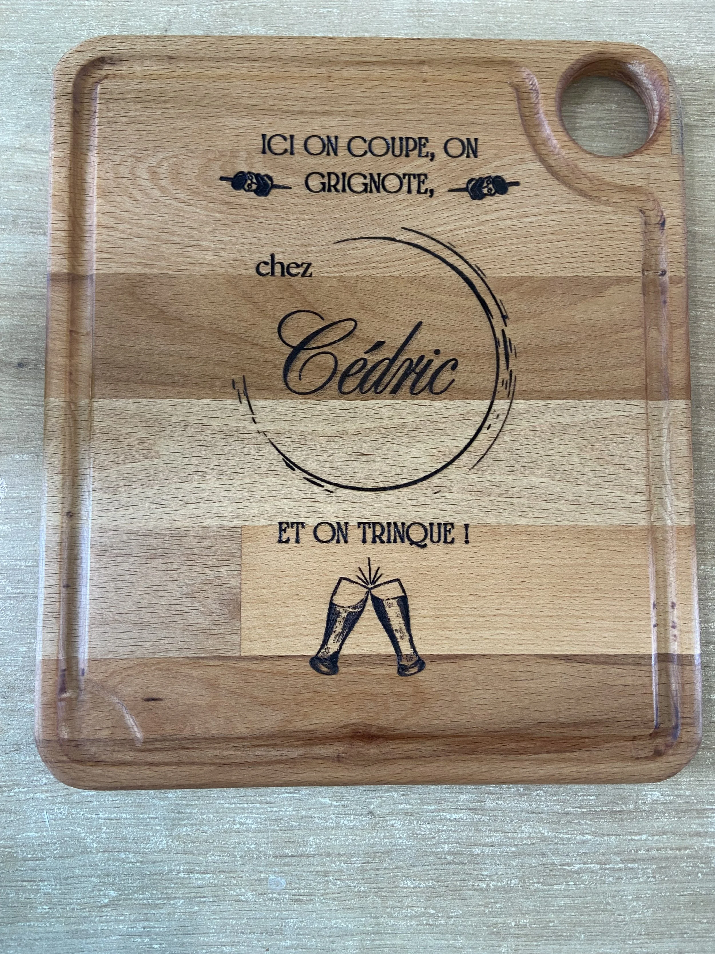 A wooden serving tray with French text and a graphic of two clinking champagne glasses