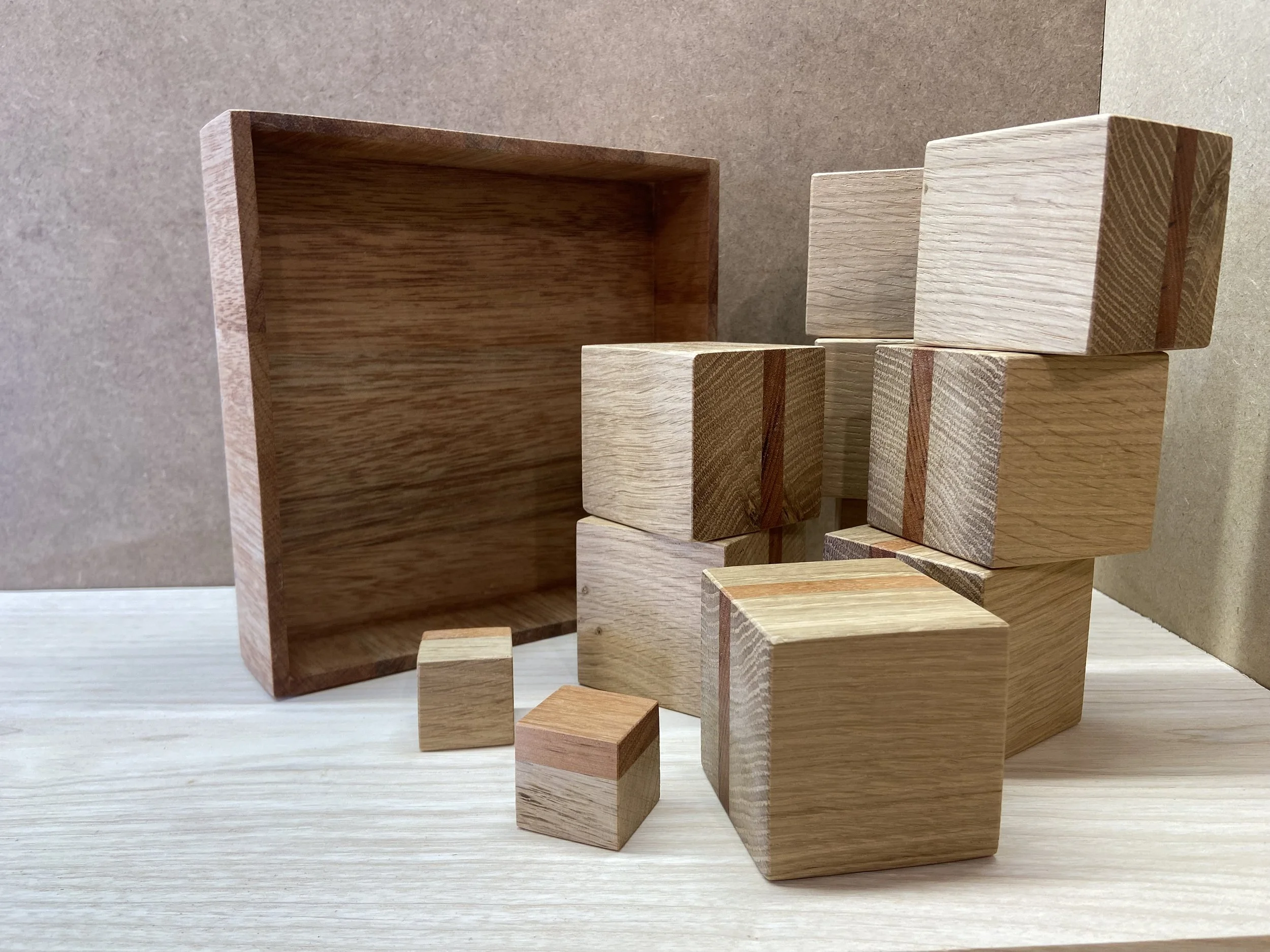 Various wooden blocks and a wooden box on a light-colored surface with a brown background.