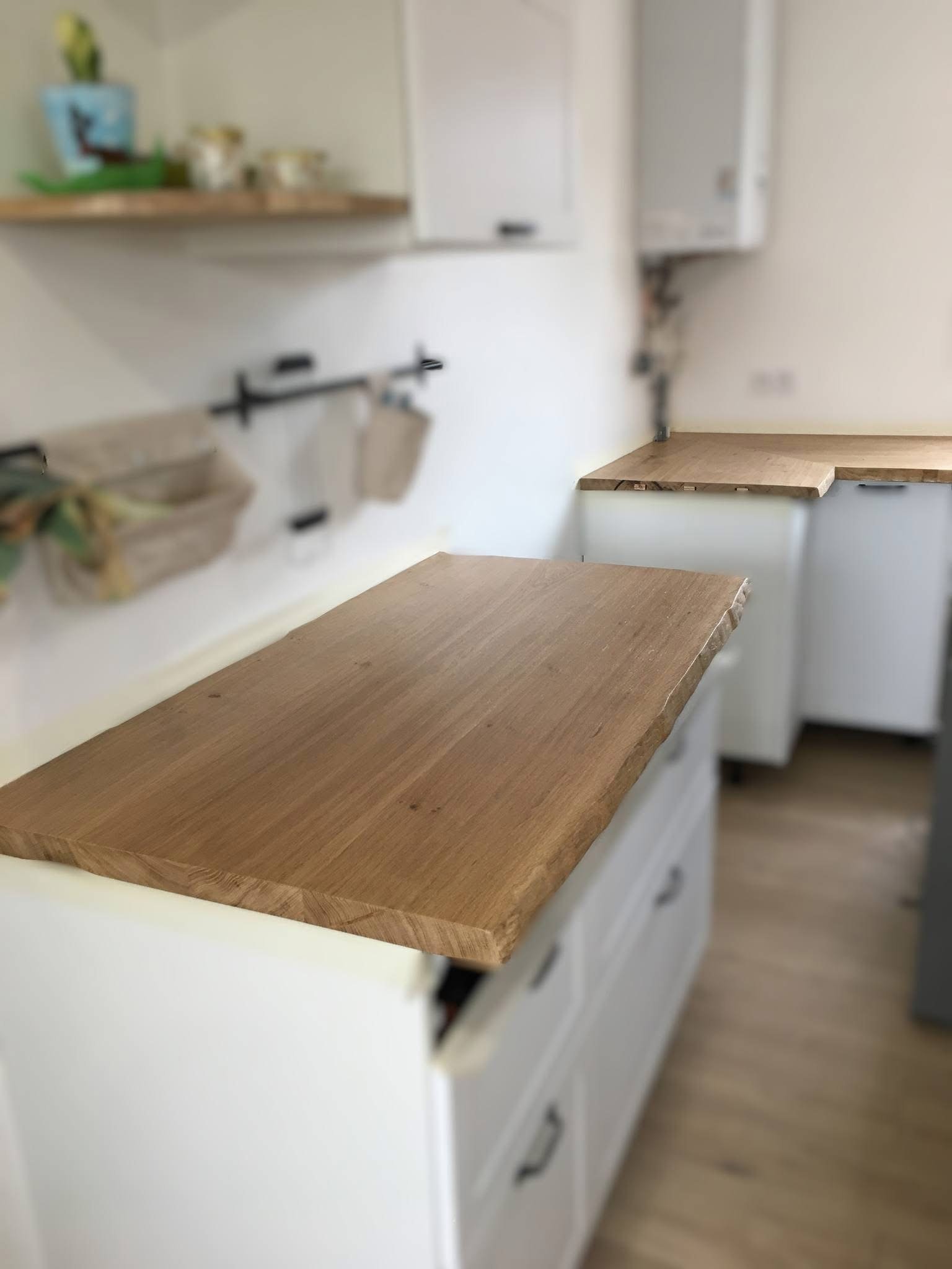 Wooden countertop in a kitchen with white cabinets.