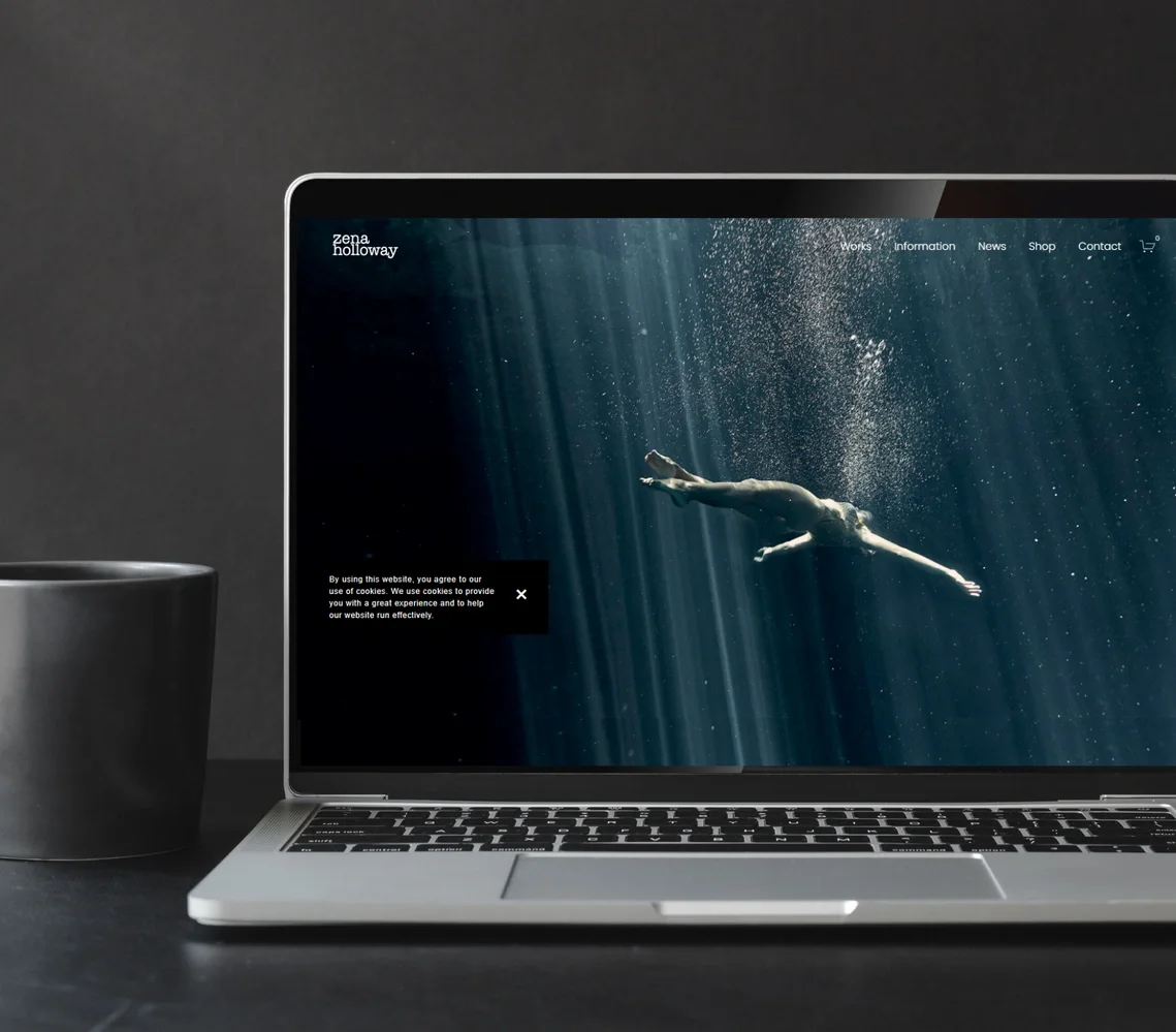 Open laptop displaying an underwater scene with a person swimming and light rays penetrating the water.