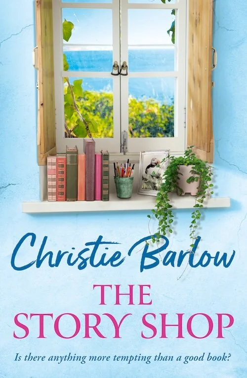 A blue window with a view of green trees and blue sky, decorated with books, a potted plant, and art supplies on a windowsill, with the title "The Story Shop" by Christie Barrow.
