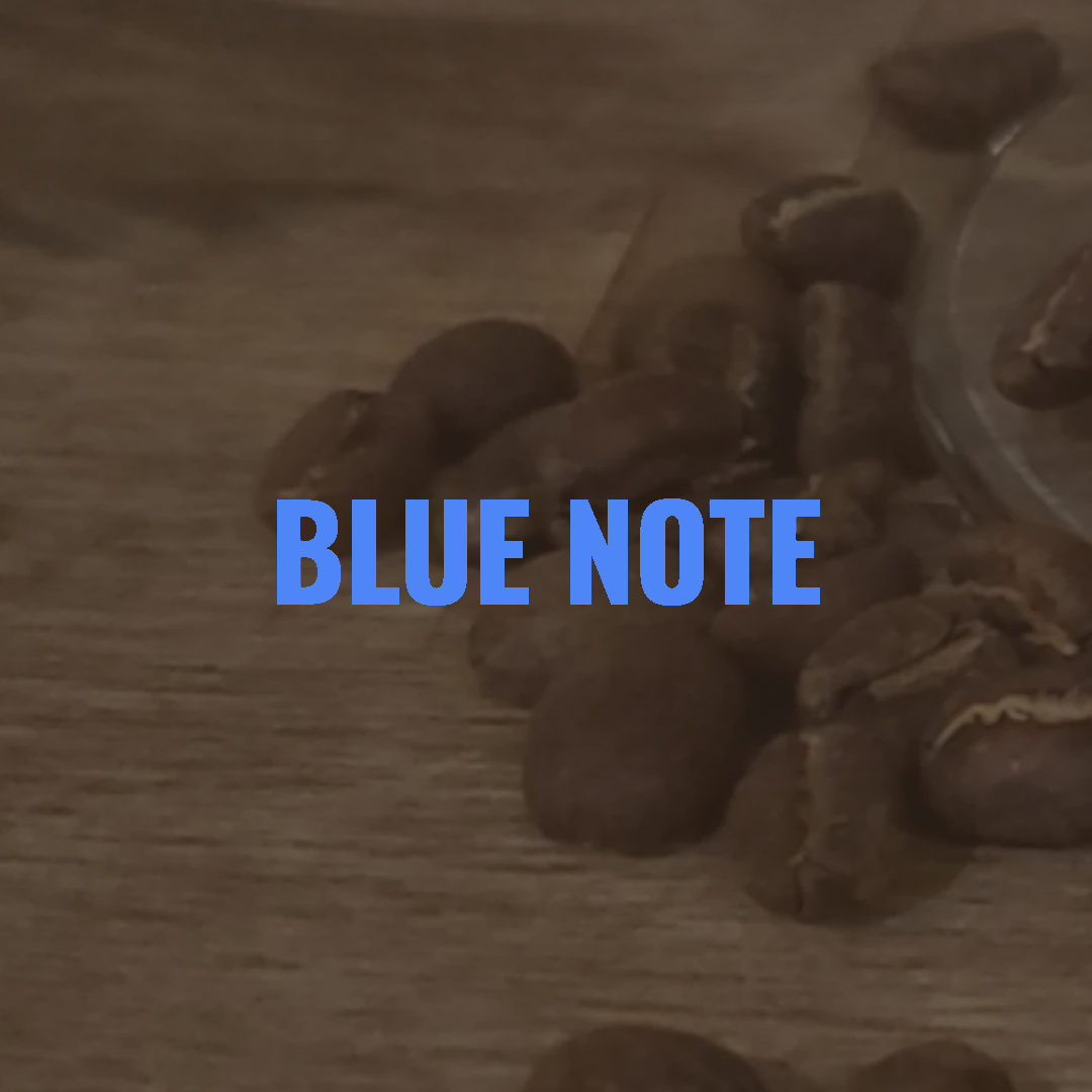 Close-up of coffee beans around a wine glass base with the words "BLUE NOTE" in blue text overlay.