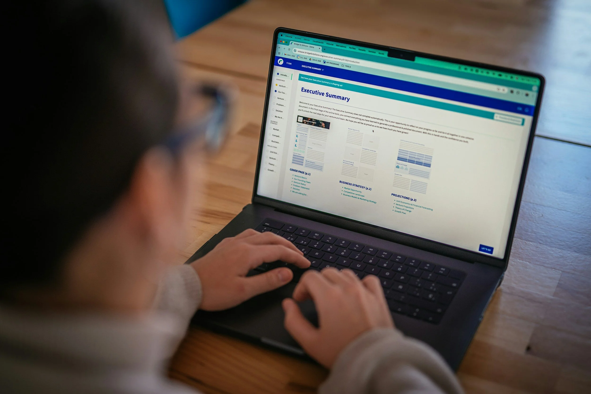 Person using a laptop to view an online document titled 'Executive Summary' with a wooden table surface.