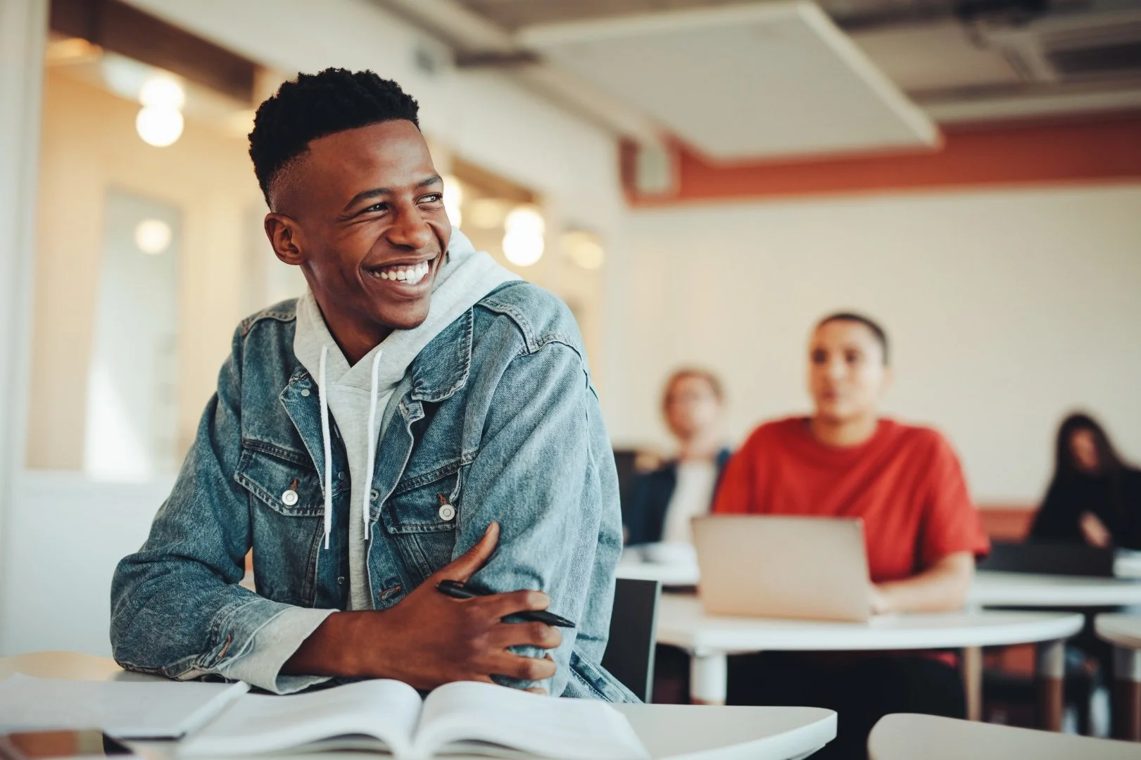 A smiling young student in a University class.