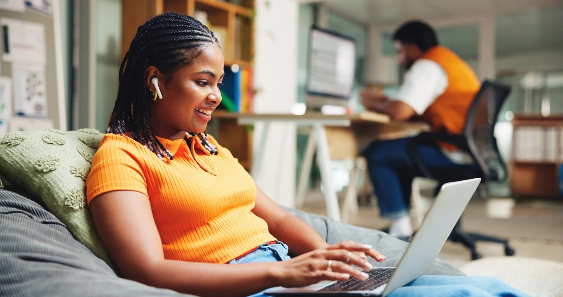 A smiling young student while studying in her laptop in the University's library.
