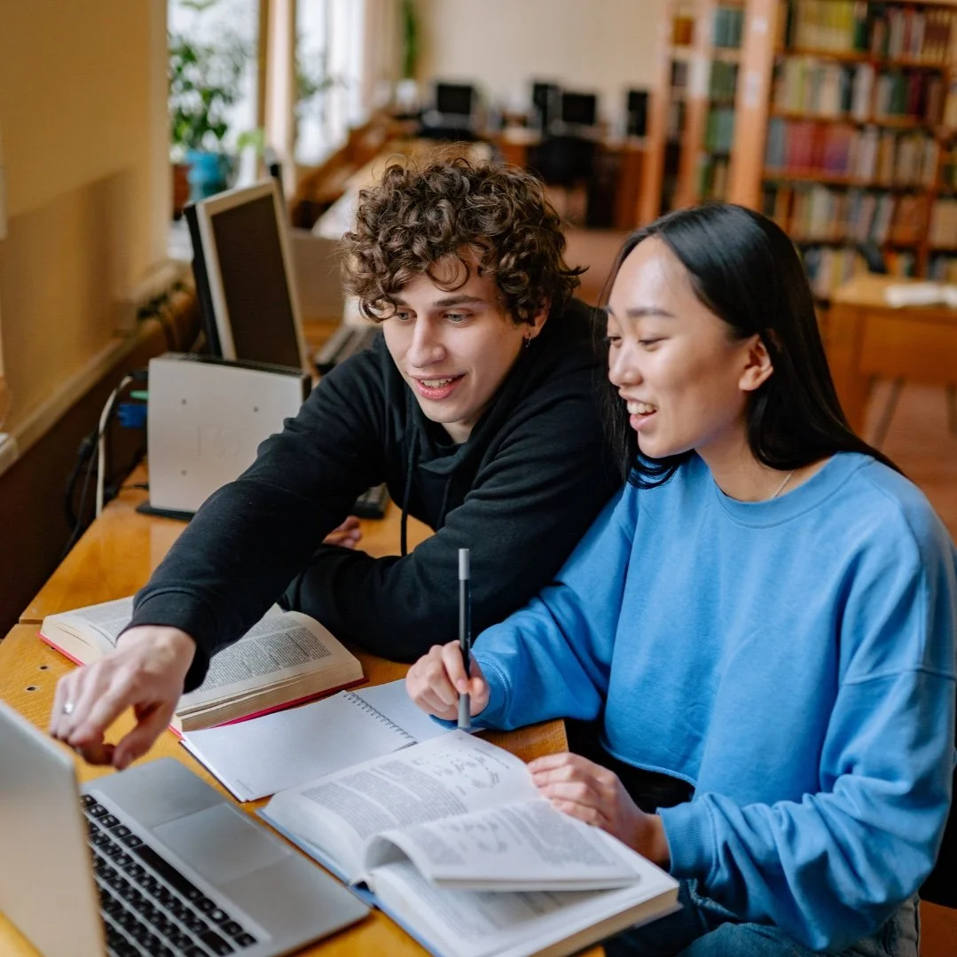Two students while studying together for their tomorrow class in a University library.