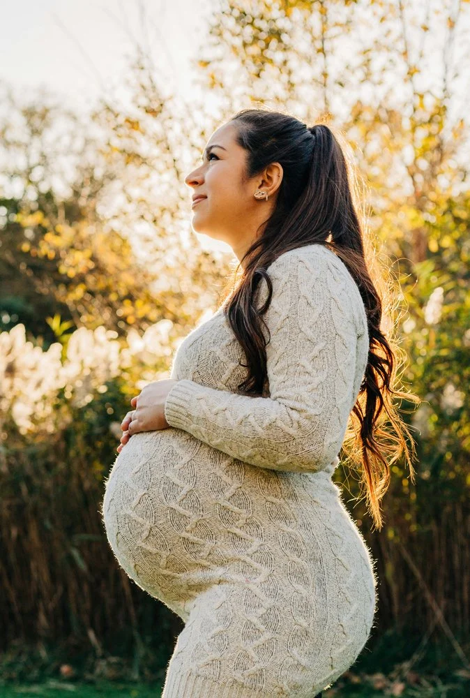 The profile of a pregnant mom smiling looking up at the sky as she attends her guided mama blessing ceremony