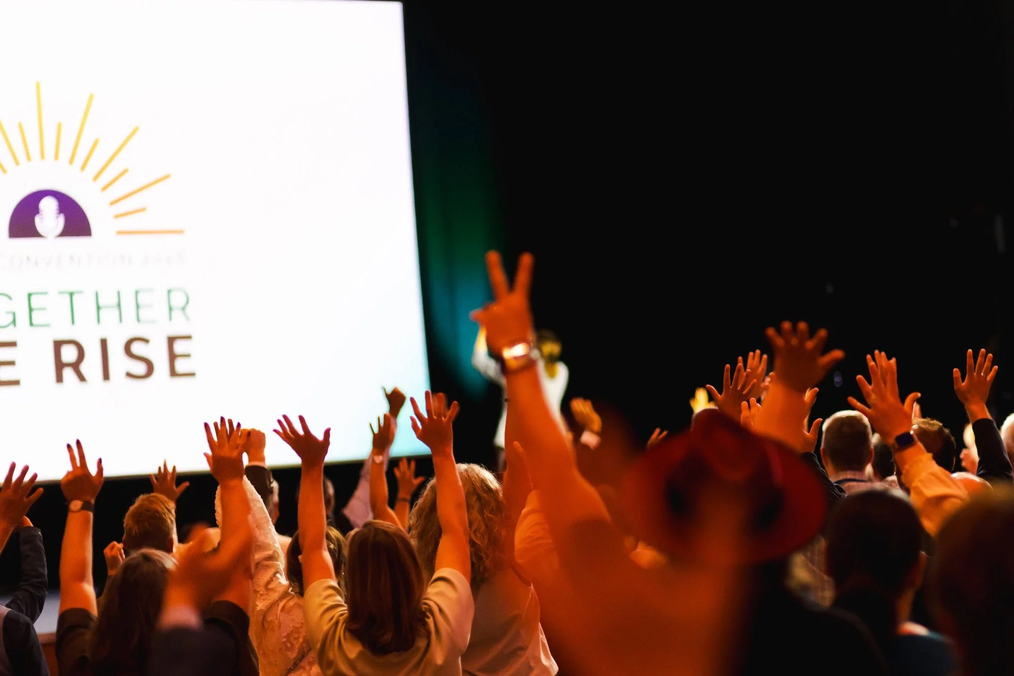 Publikum der GSA Convention 2026 mit erhobenen Händen vor der Leinwand mit dem Convention-Motiv