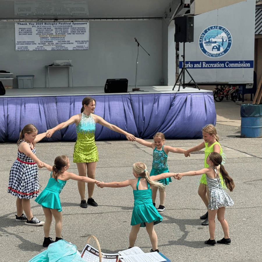 Dancers performing outside in green and yellow costumes in Emmett, MI