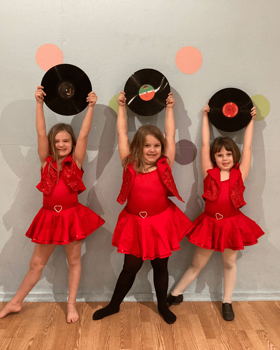 Dancers in red costume holding records in class at Crazy Moves Dance Studio
