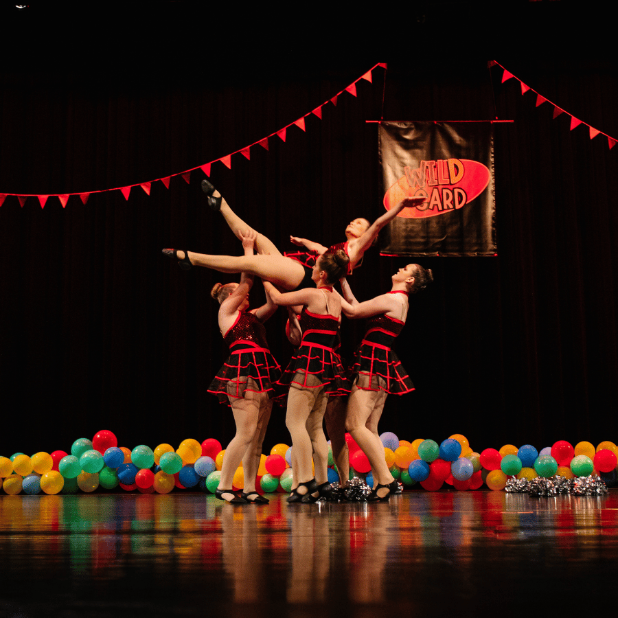 Dancers in black and red costumes performing in dance recital | Crazy Moves Dance Studio
