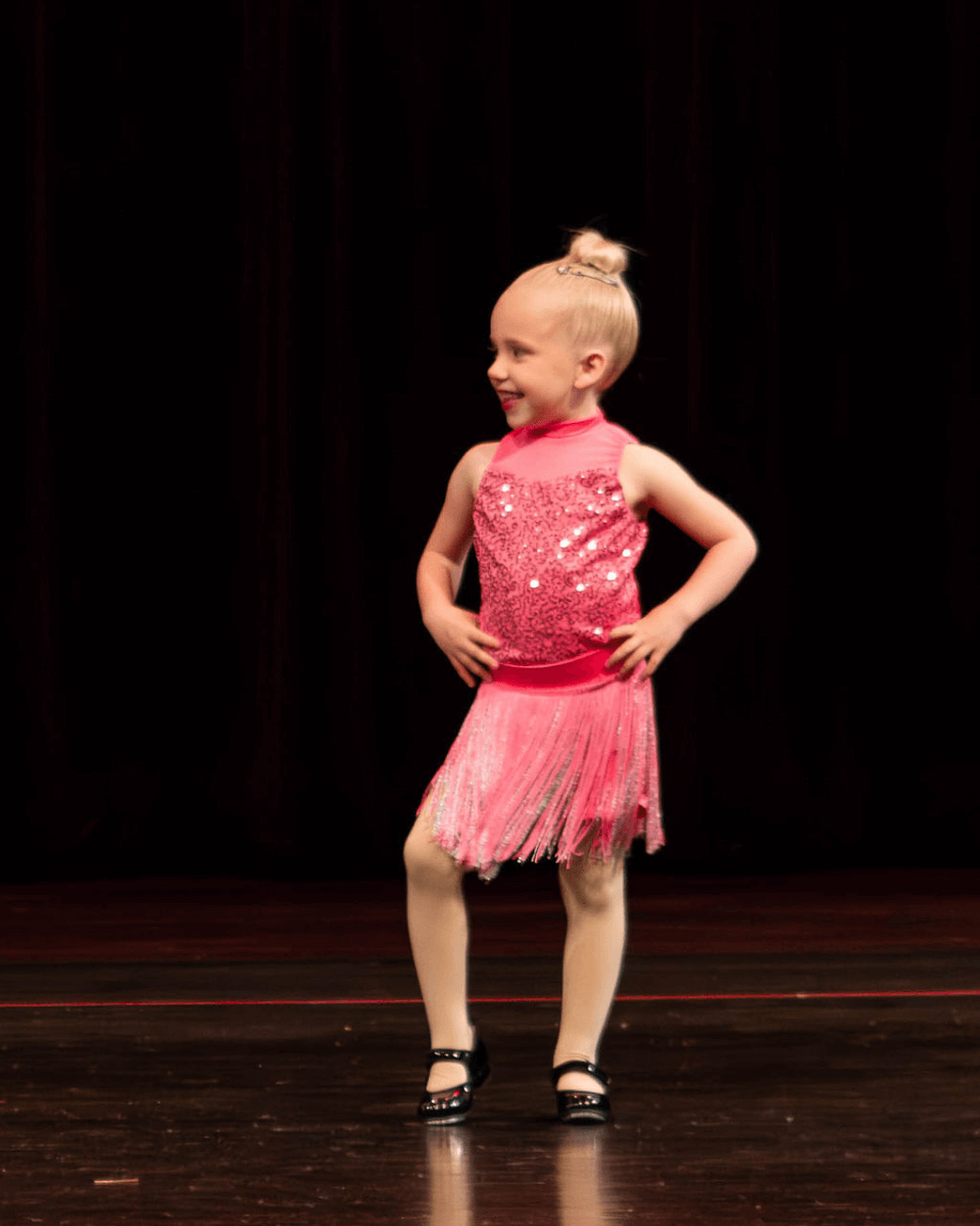 Preschool dancer in pink costume at dance recital