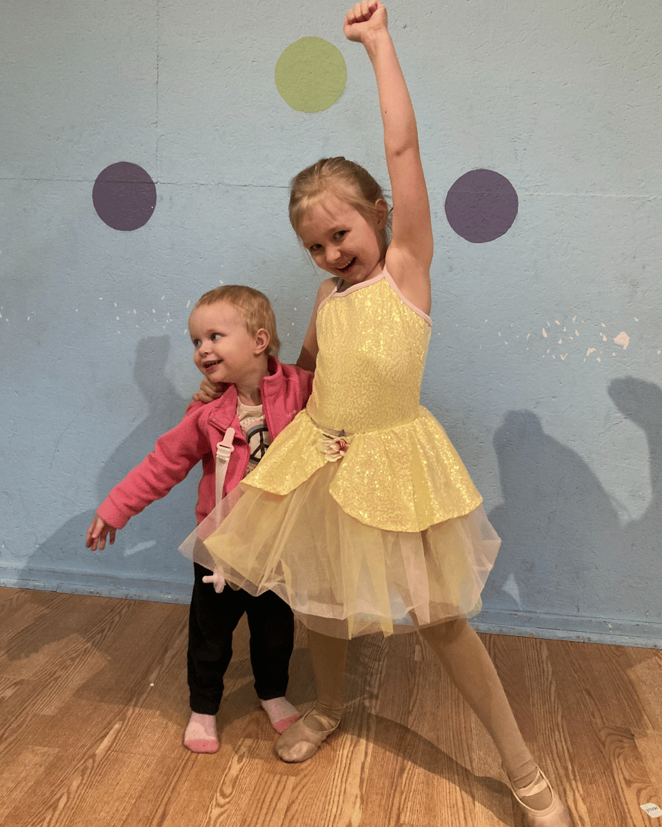 Dancer in yellow costume with younger sibling posing at Crazy Moves Dance Studio in Emmett, MI