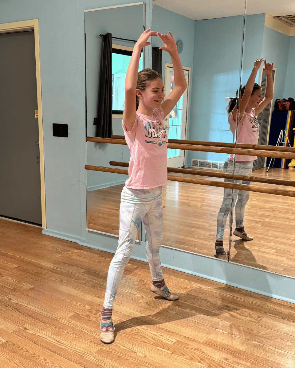 Young dancer at ballet barre working on balance