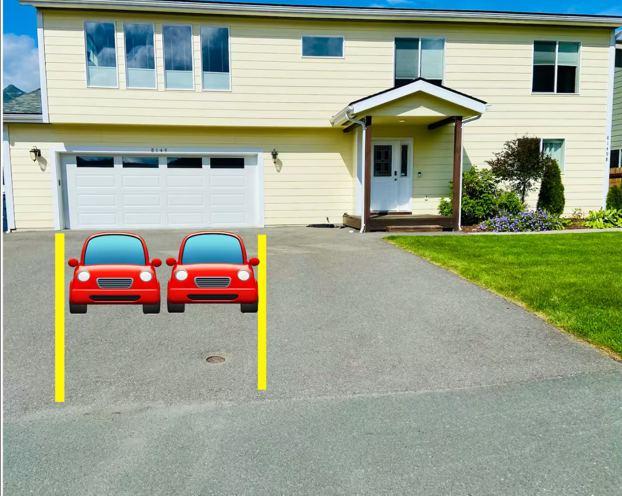 A yellow two-story house with a white garage door, a front porch with a small roof supported by two wooden posts, and a well-maintained front yard with green grass and purple flowers. There are two cartoon-style red cars parked in a designated parking space marked by yellow lines in the driveway.