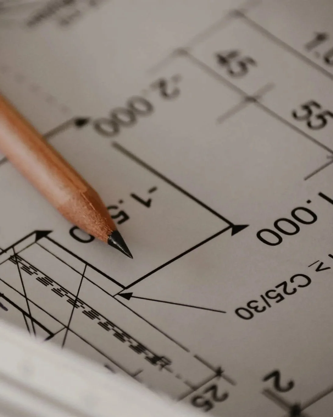 Dessin technique avec un crayon de couleur orange posé dessus.