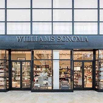 Williams Sonoma store entrance with glass doors and windows, interior shelves, and a sign indicating it's in California.