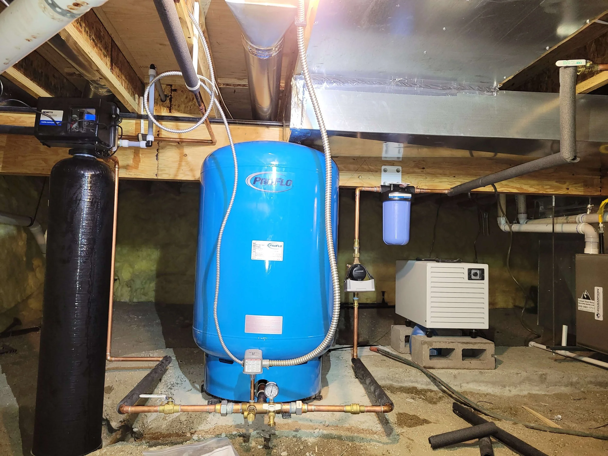 Basement setup with water tank, pipes, and filter