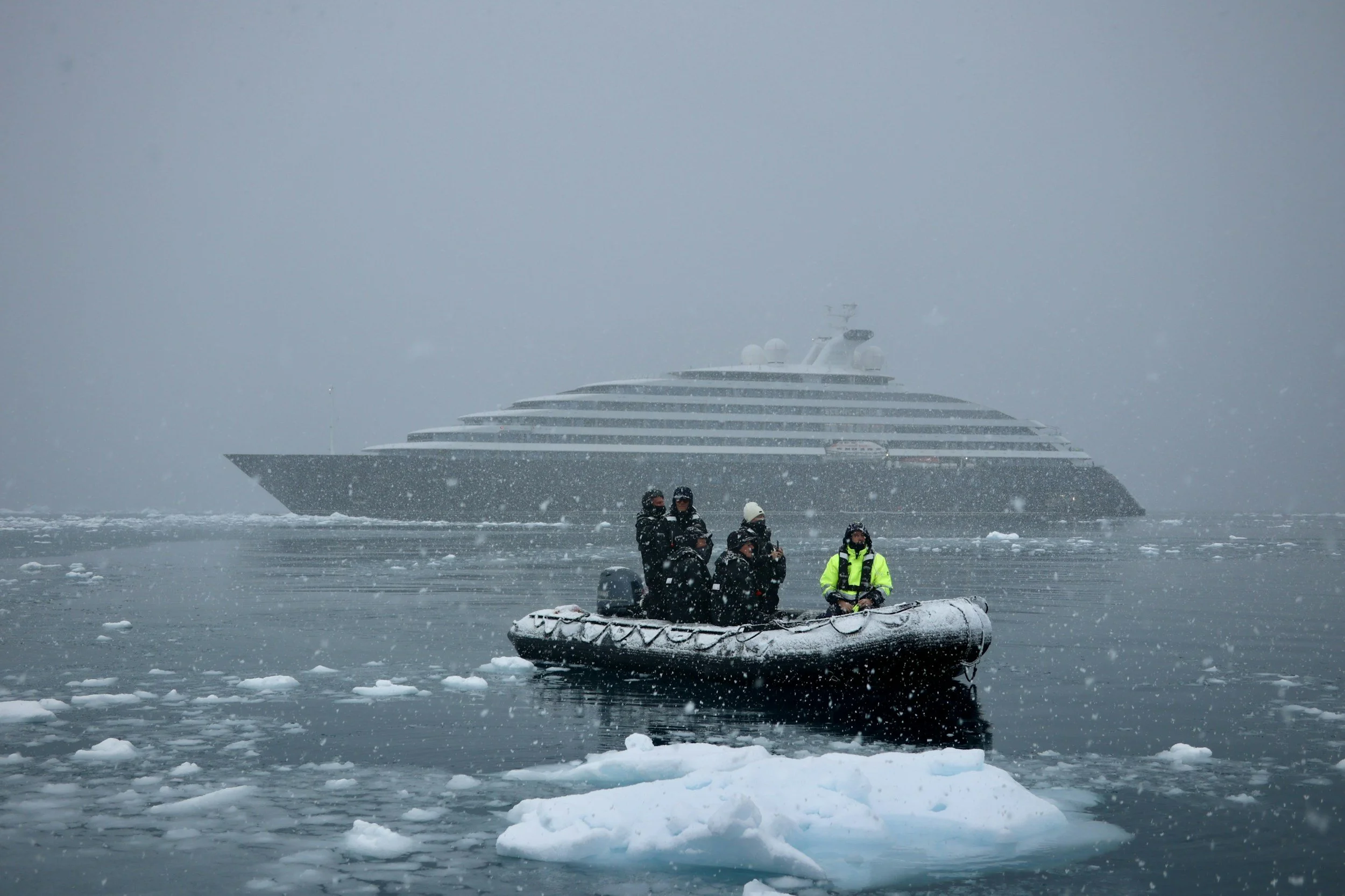 A luxury expedition ship navigating a remote coastline, representing the National Geographic certified expedition travel and diving services offered by Kimber Travis.