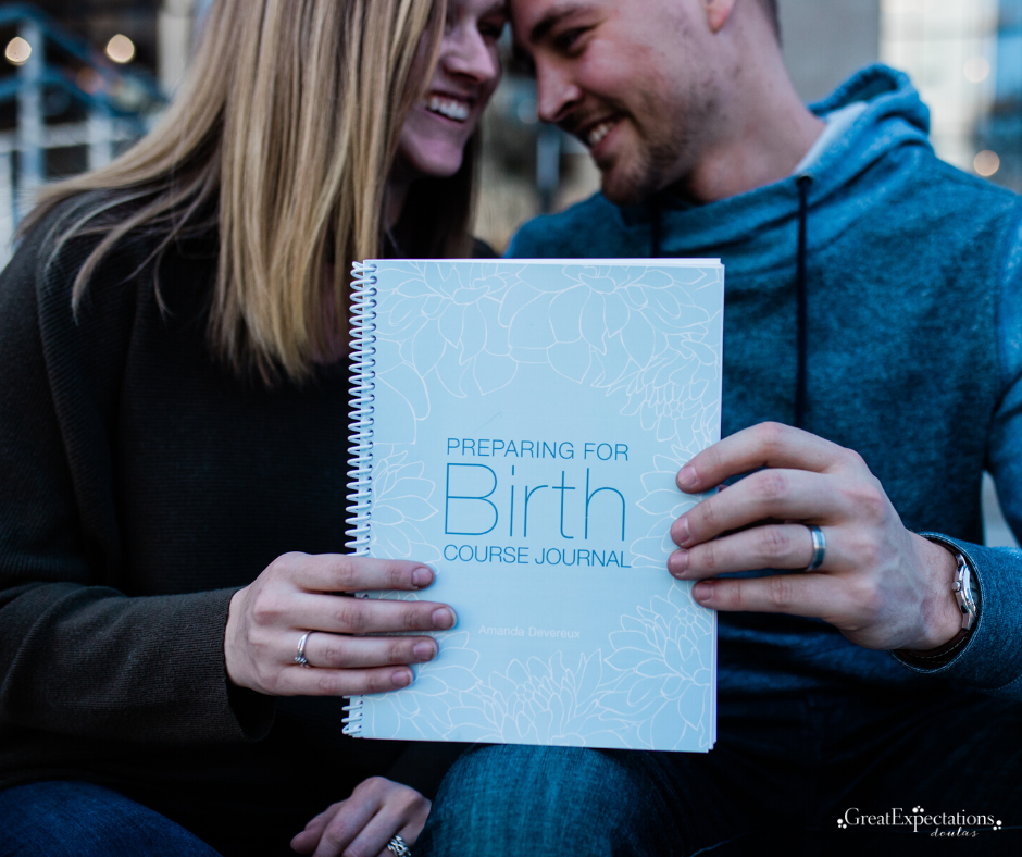 A couple smiling and holding a 'Preparing for Birth Course Journal' together.