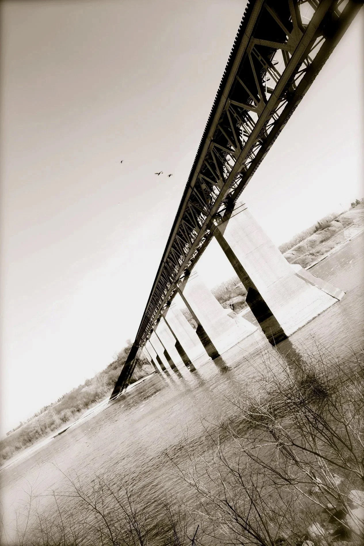 Black and white architectural photograph of a bridge over the South Saskatchewan River in Saskatoon.