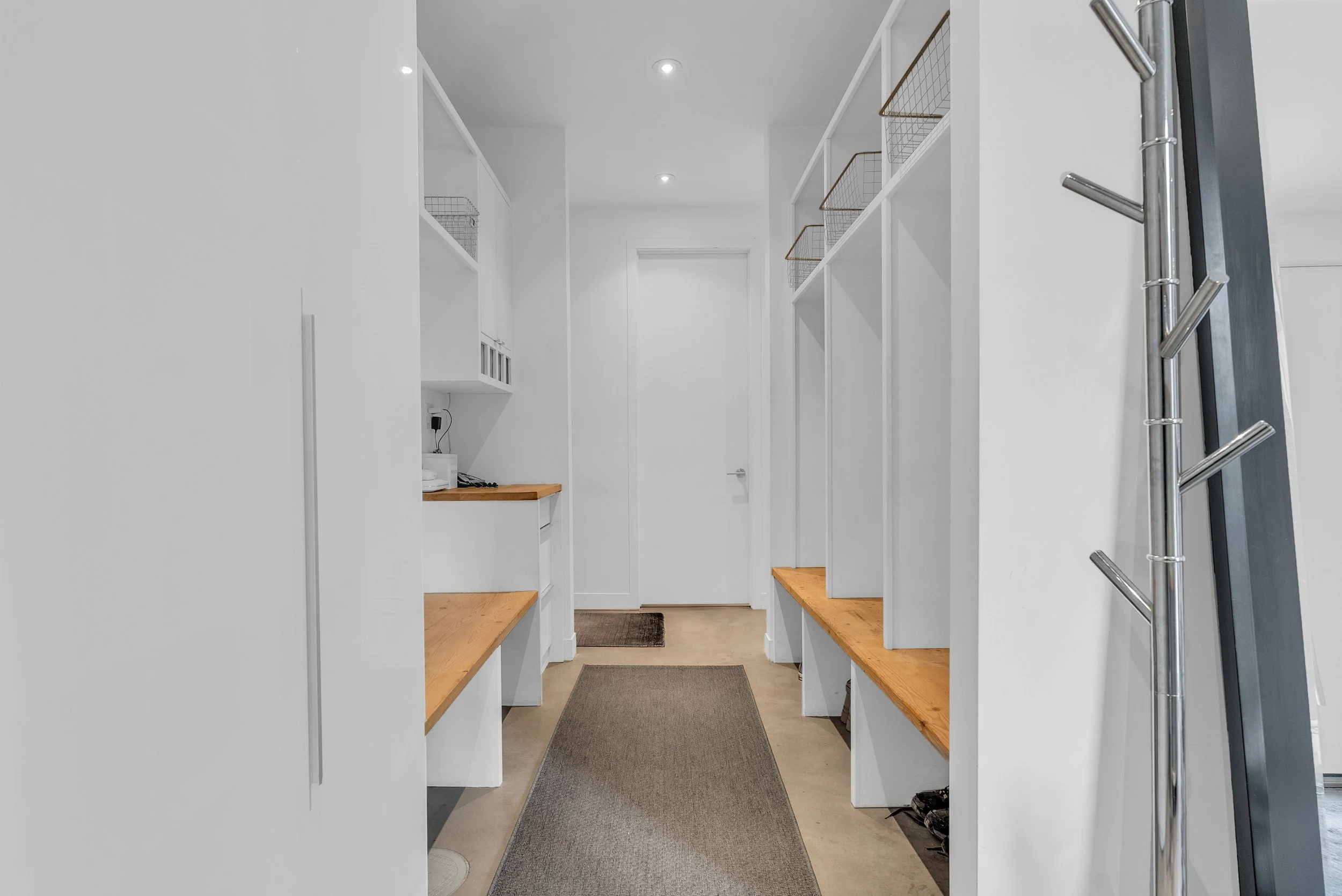 Custom mudroom with built-in storage, minimalist millwork, and warm wood bench details.