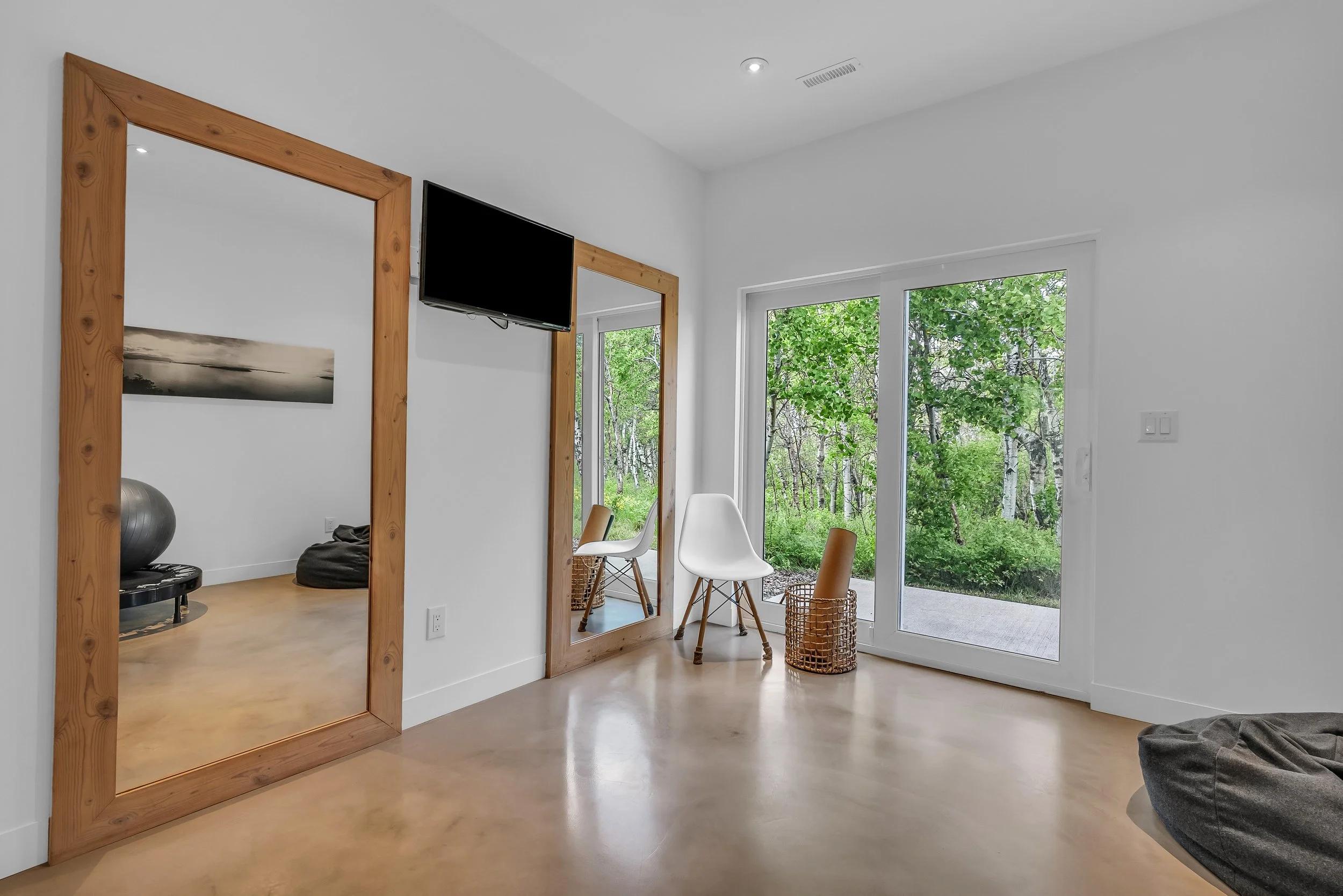 Custom fitness room with concealed play space and minimalist modern finishes.