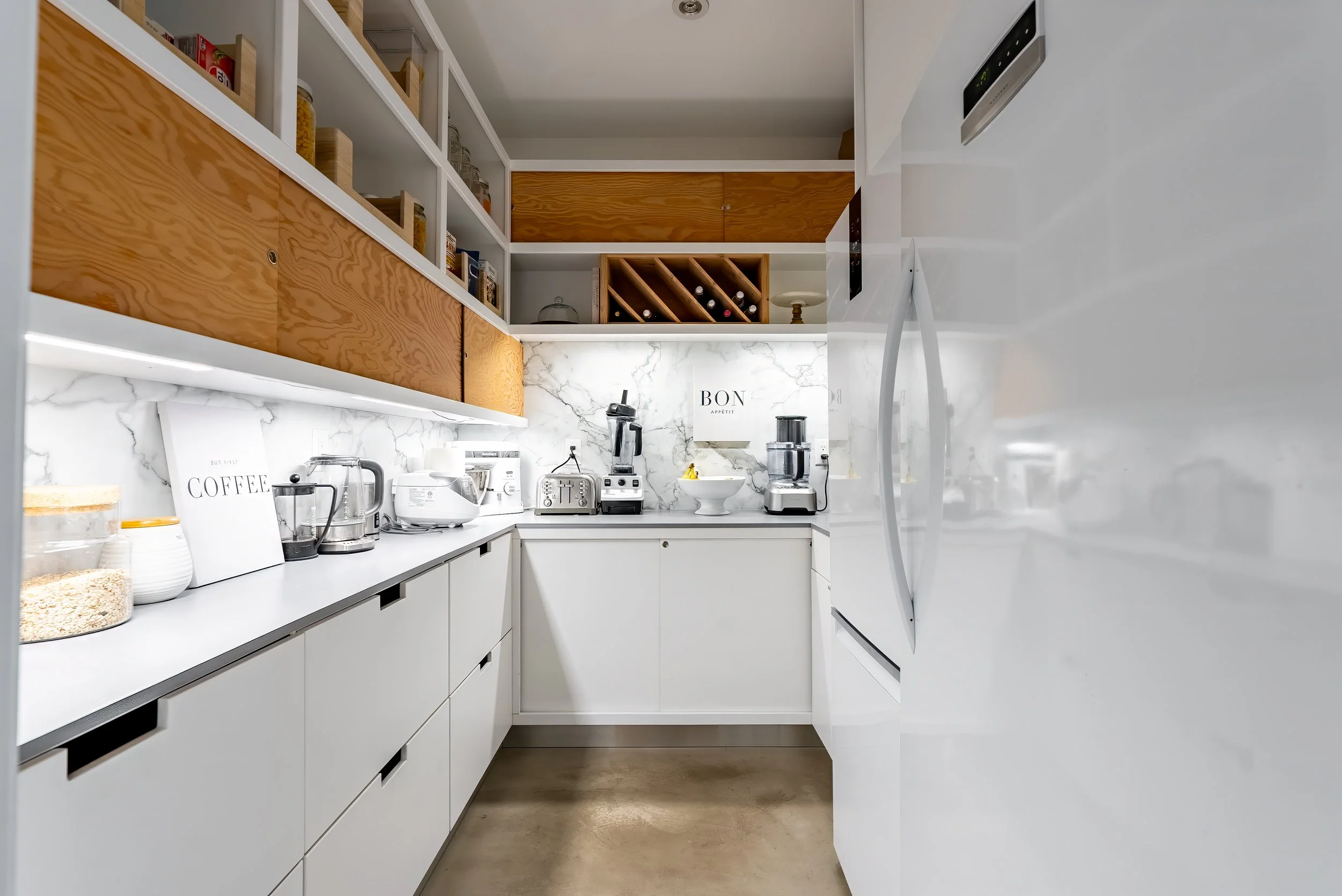 Custom pantry with integrated storage, open shelving, and warm wood details.