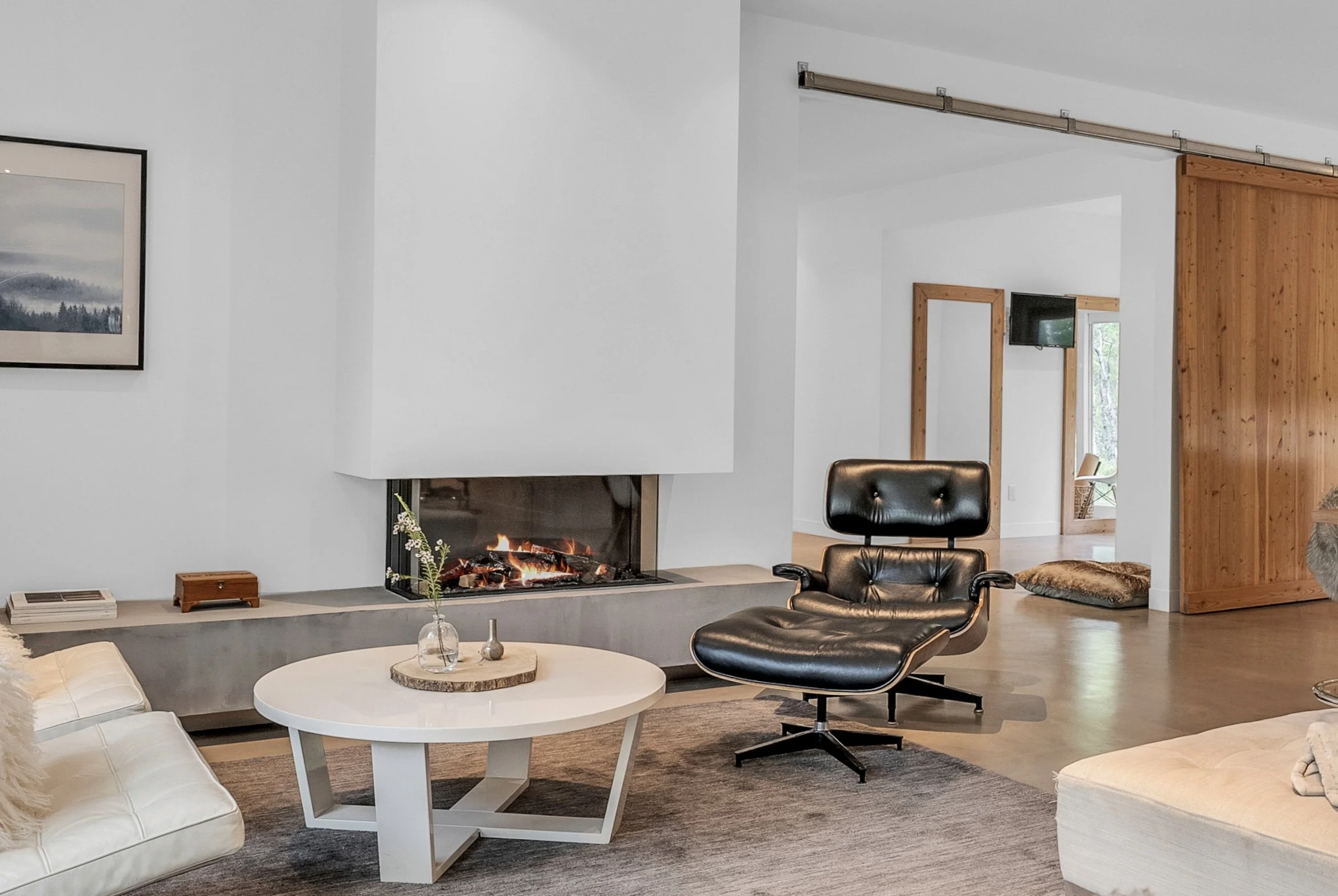 Modern custom home featuring a concrete fireplace bench, warm wood accents, and open-concept living.