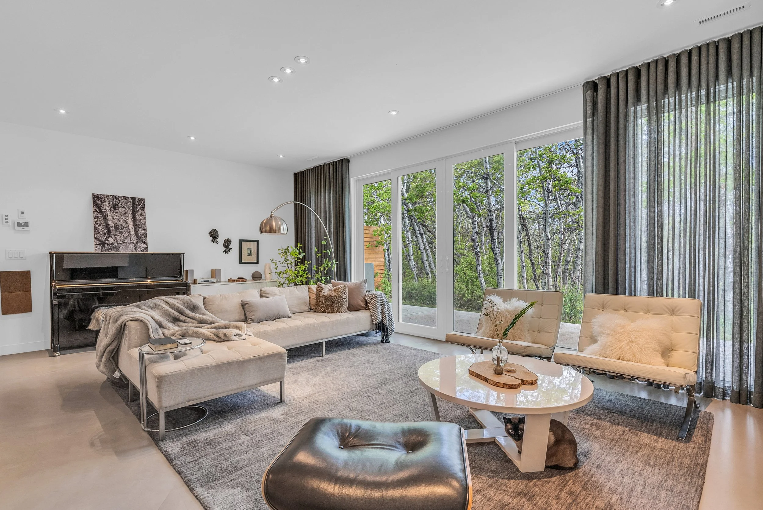 Modern great room with expansive windows and warm natural finishes.