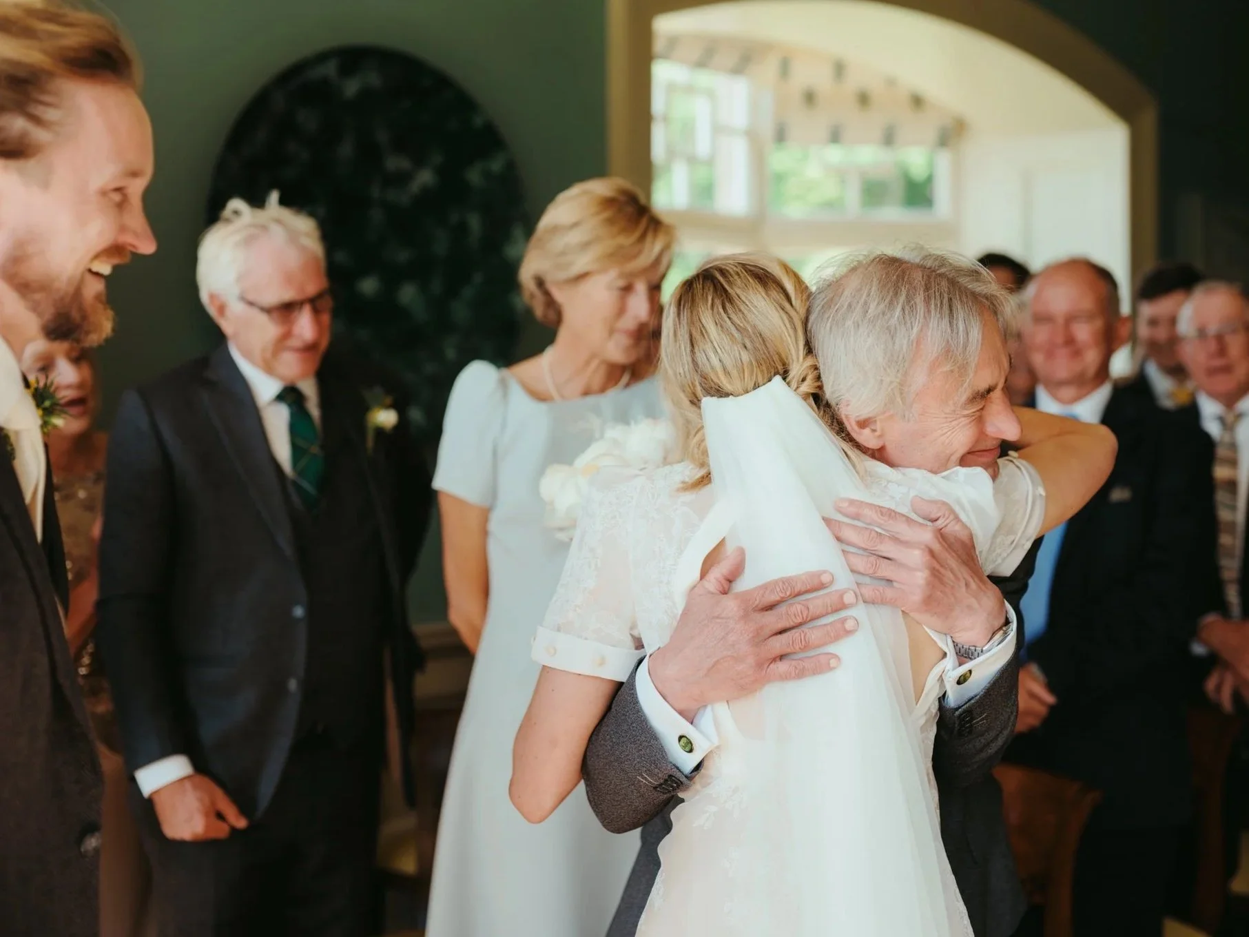 father of the bride hugs daughter after he walks her down the aisle