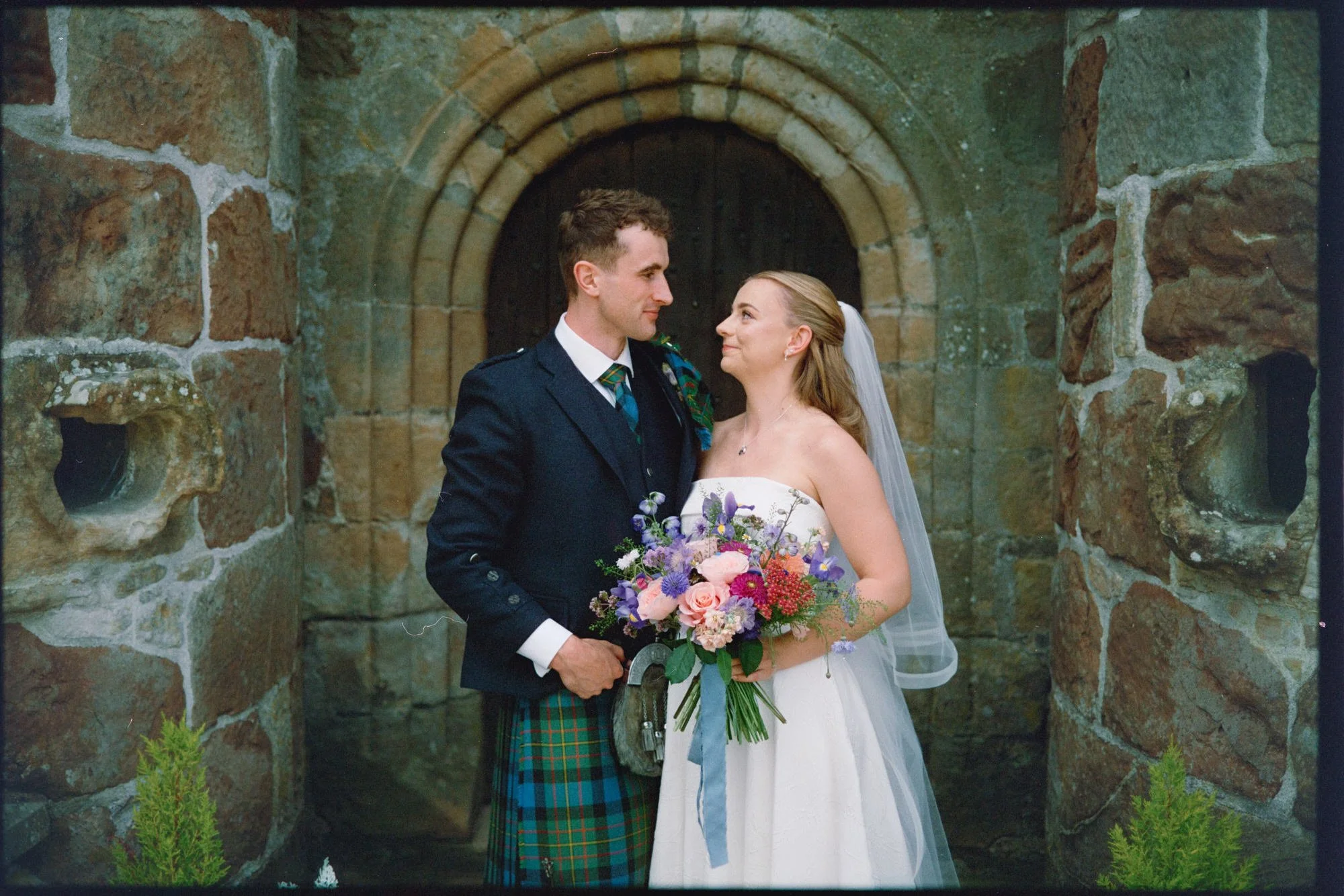 A candid newlywed moment in the castle grounds