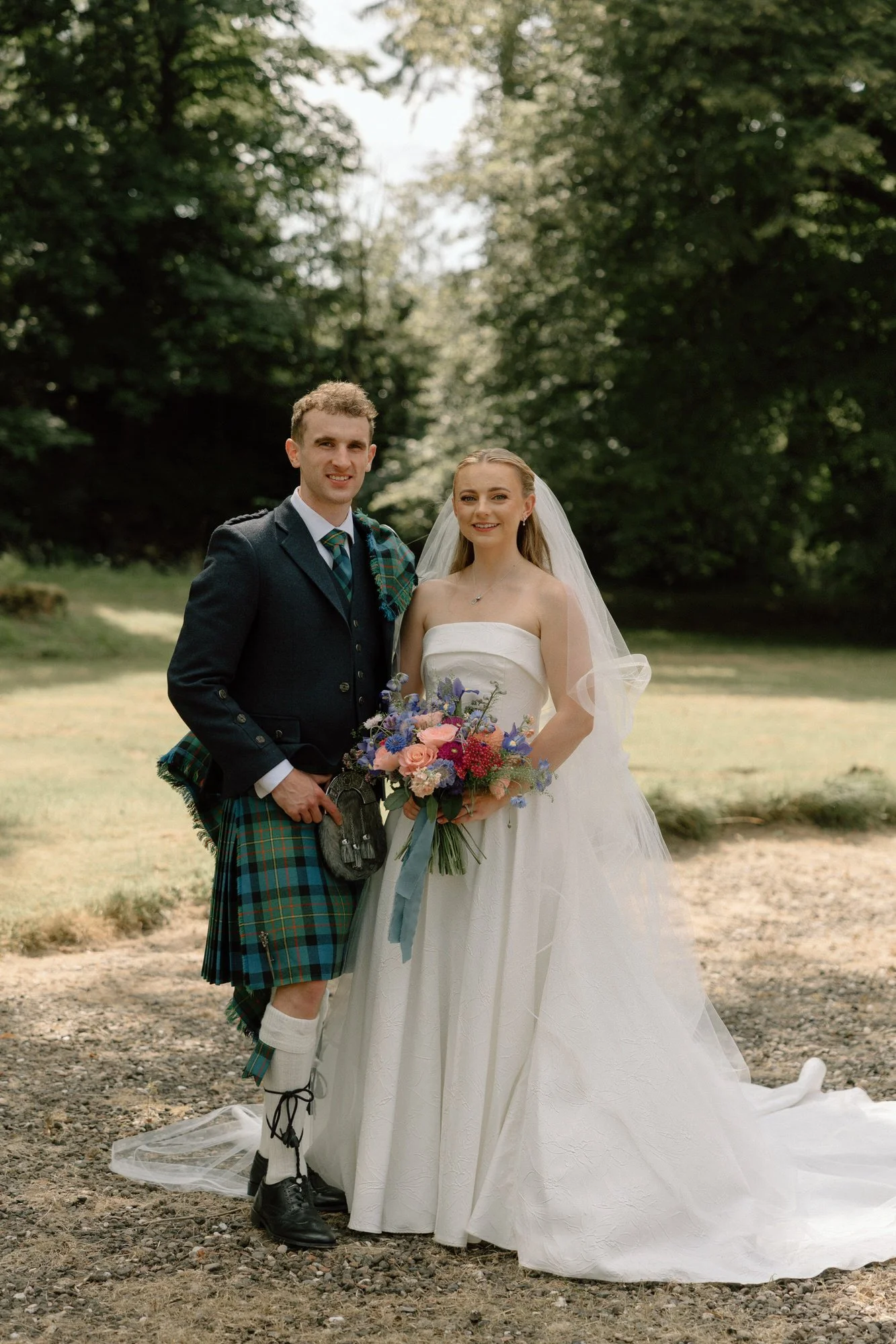 Newlyweds walking beside the old walls of Rowallan Castle