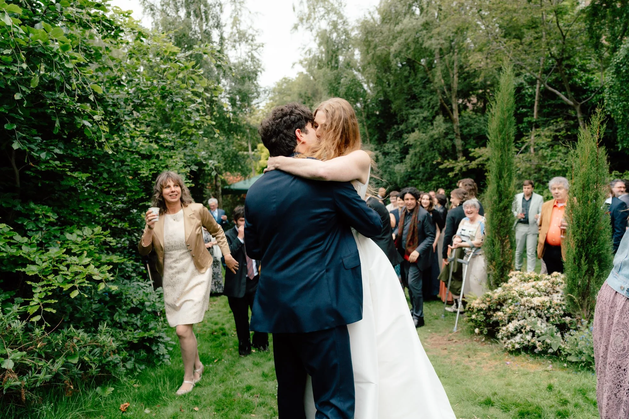 Candid wedding guest dancing outdoors on the lawn