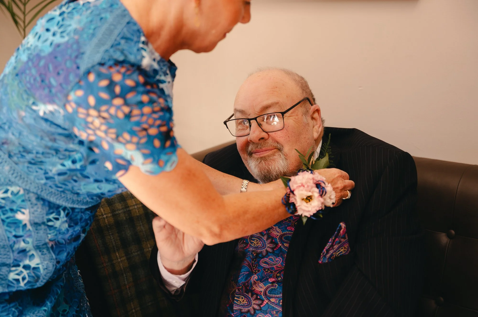 Family member having a buttonhole pinned before the St Andrews ceremony