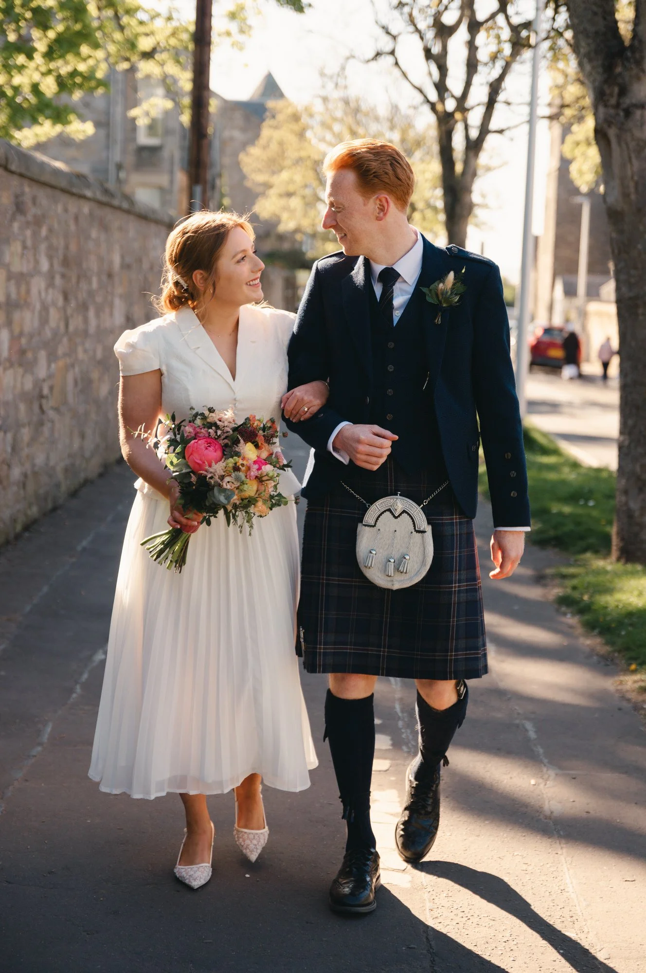 Natural couple portrait beside the historic stone buildings of St Andrews