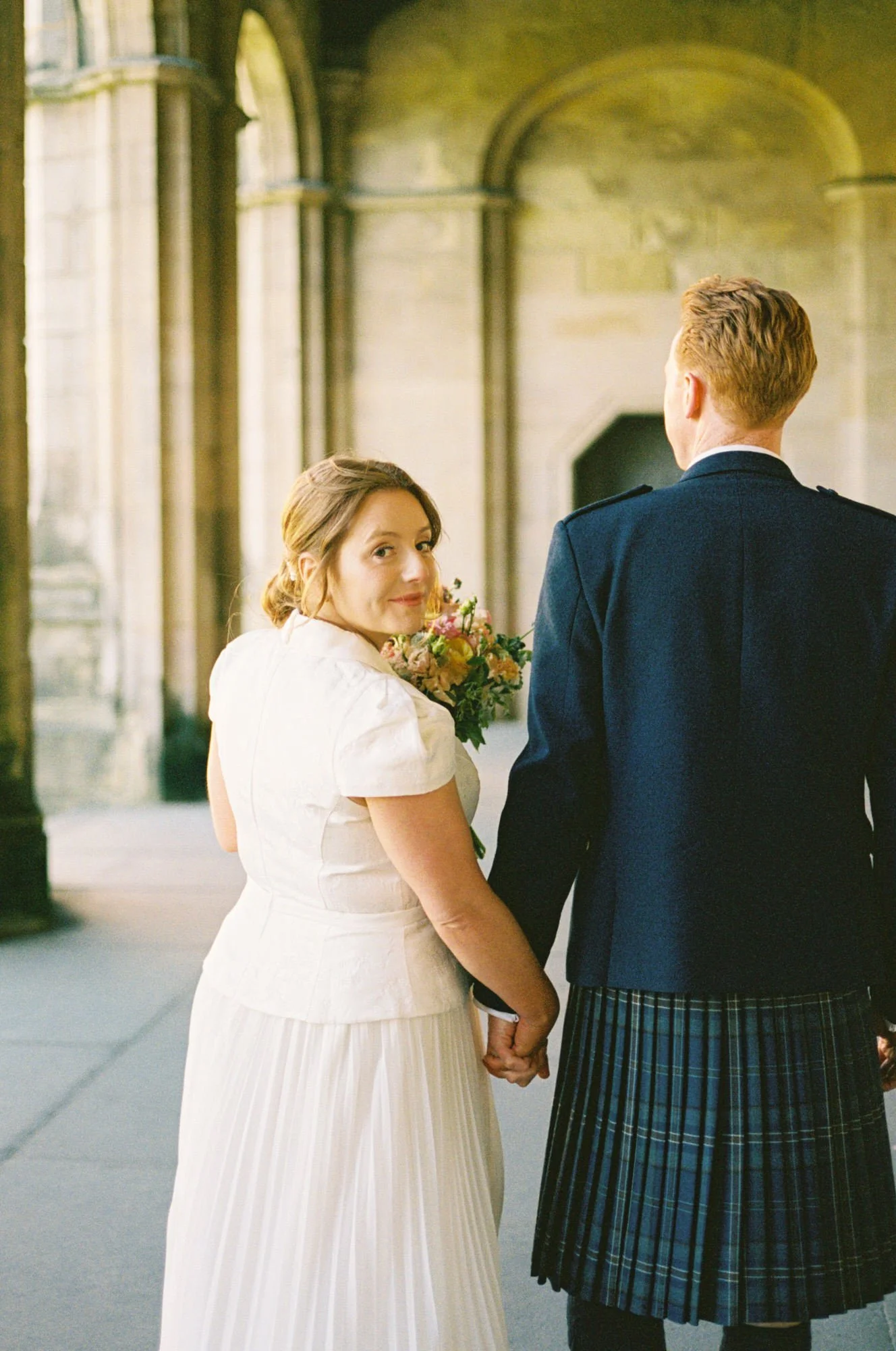 Hazel and Ally walking through St Andrews after their wedding ceremony