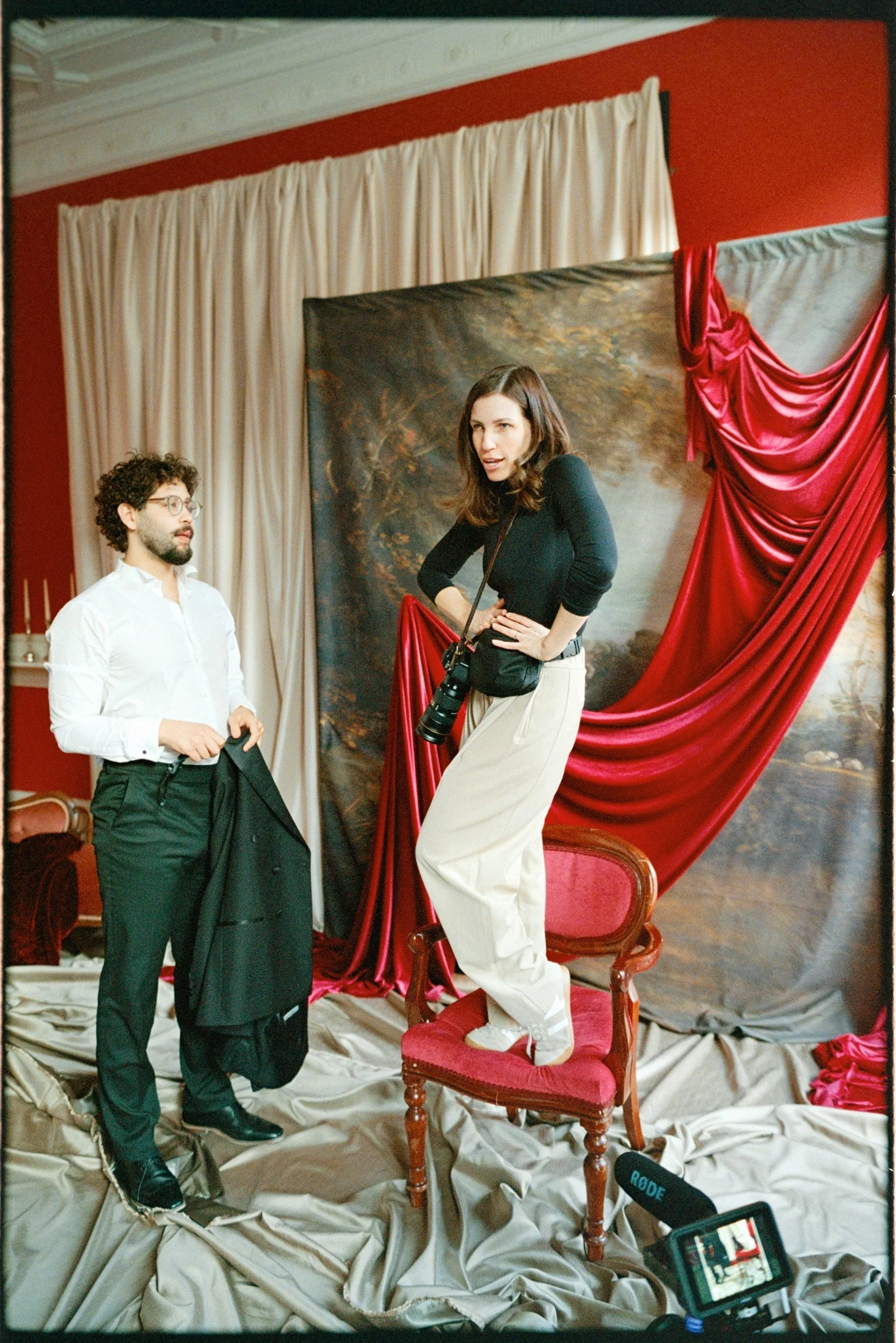 Male stage performer seated in a red-draped theatrical set on Portra 800 film